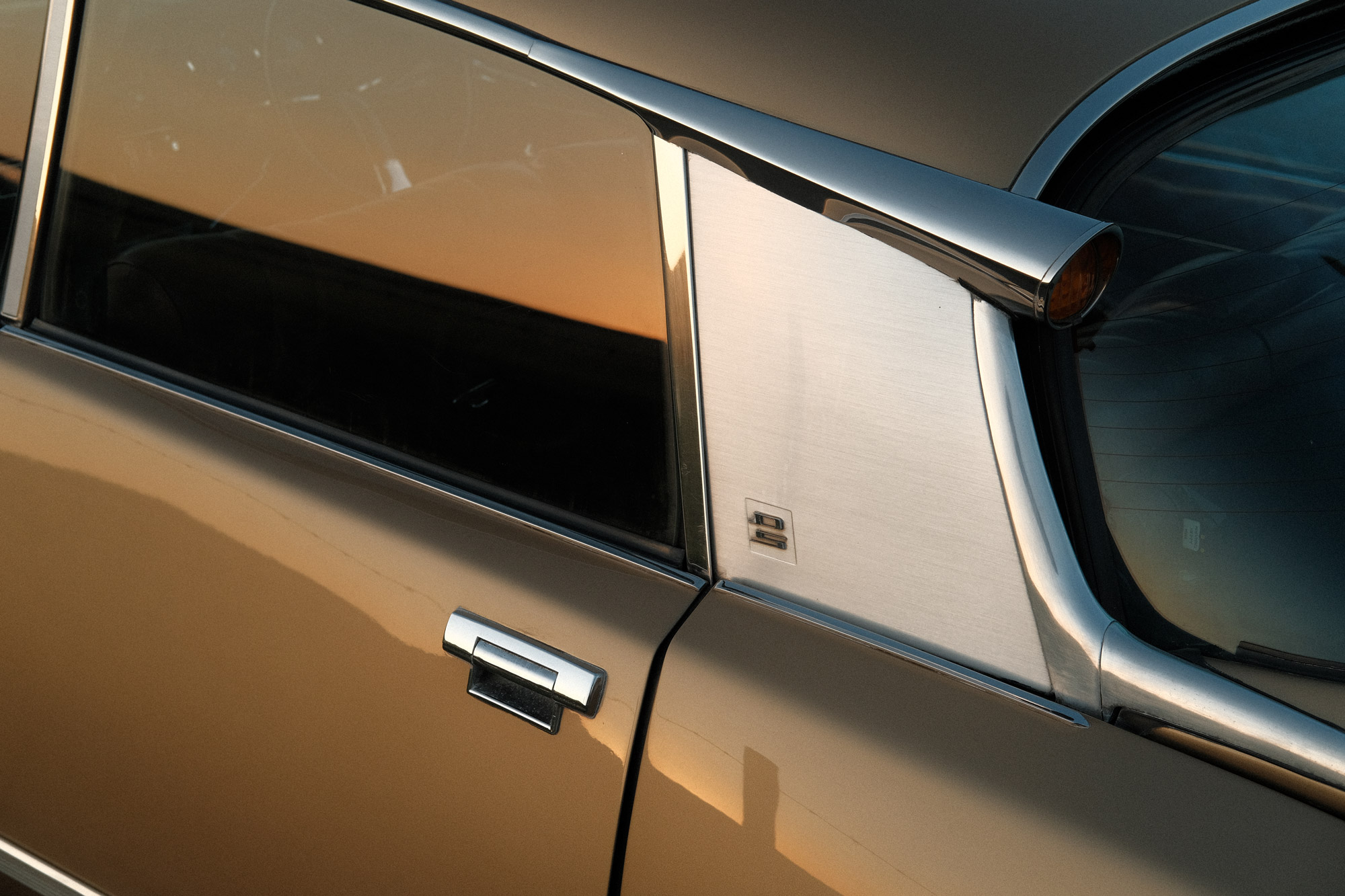 A close-up image of a retro car showing a brown door in a sepia tone, shot by Ian Howorth with the Fujifilm X-Pro3.

