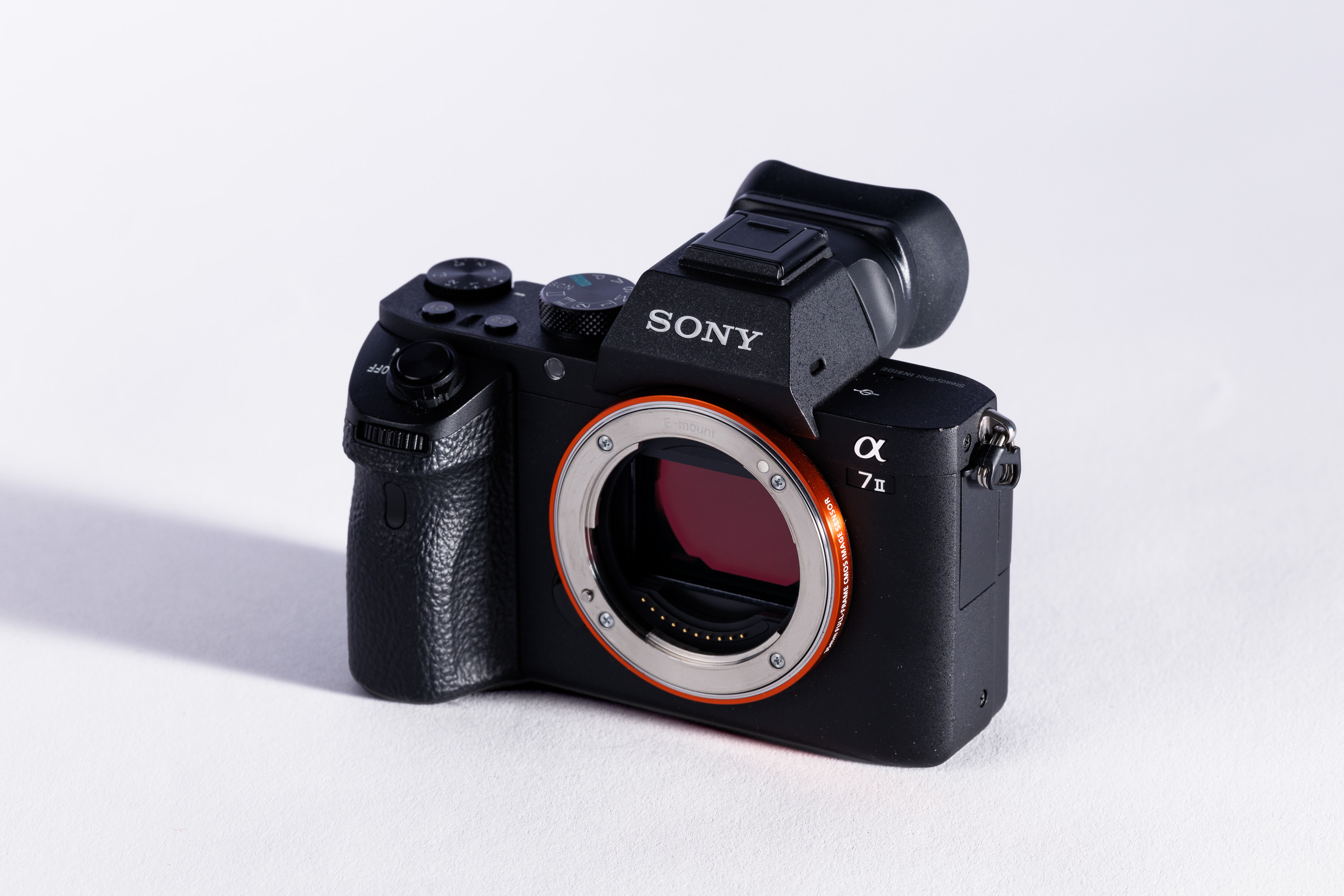 A used Sony A7 II body on a white background, with a shadow to the left. 