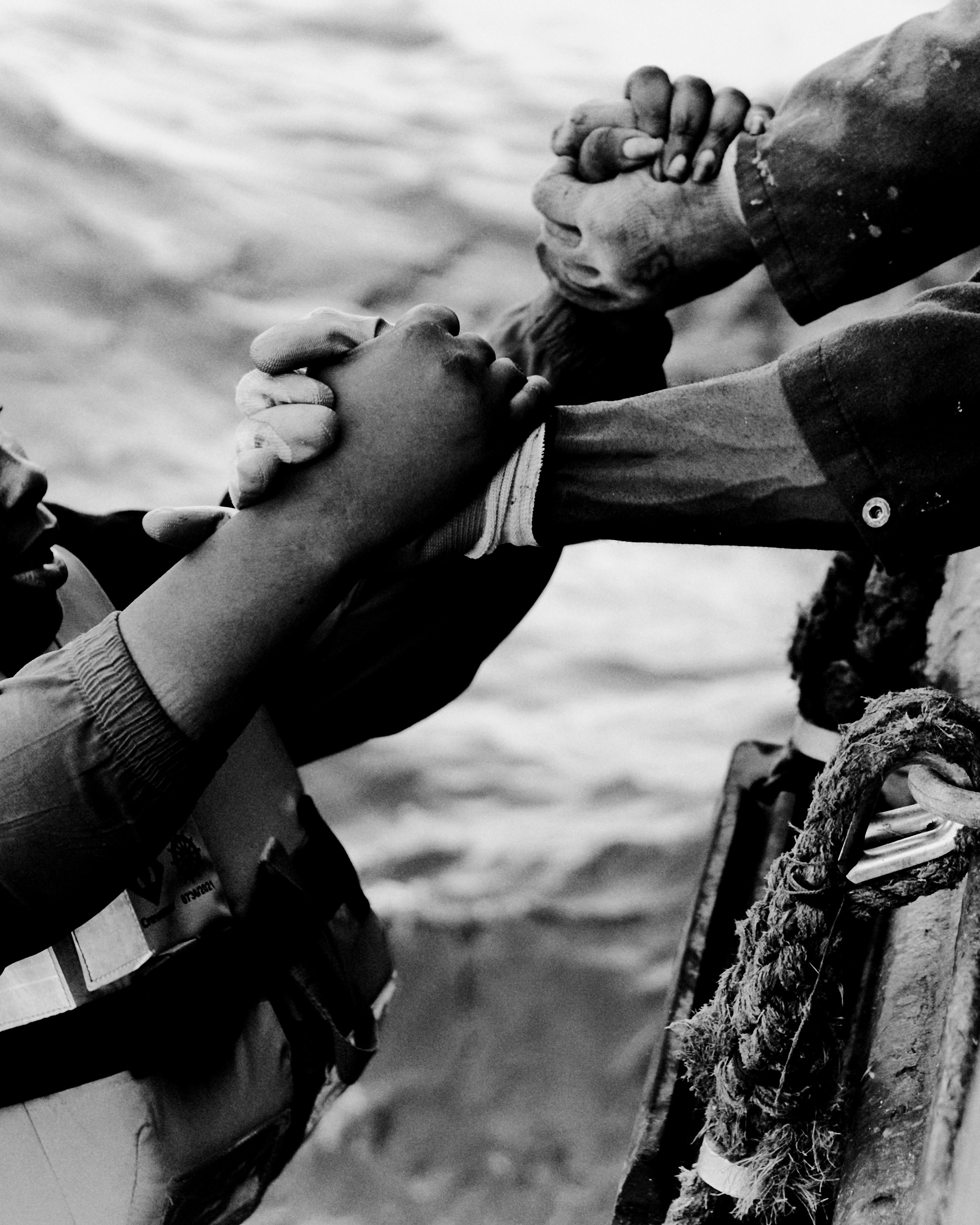 Close-up of two hands grasping the two hands of another person.