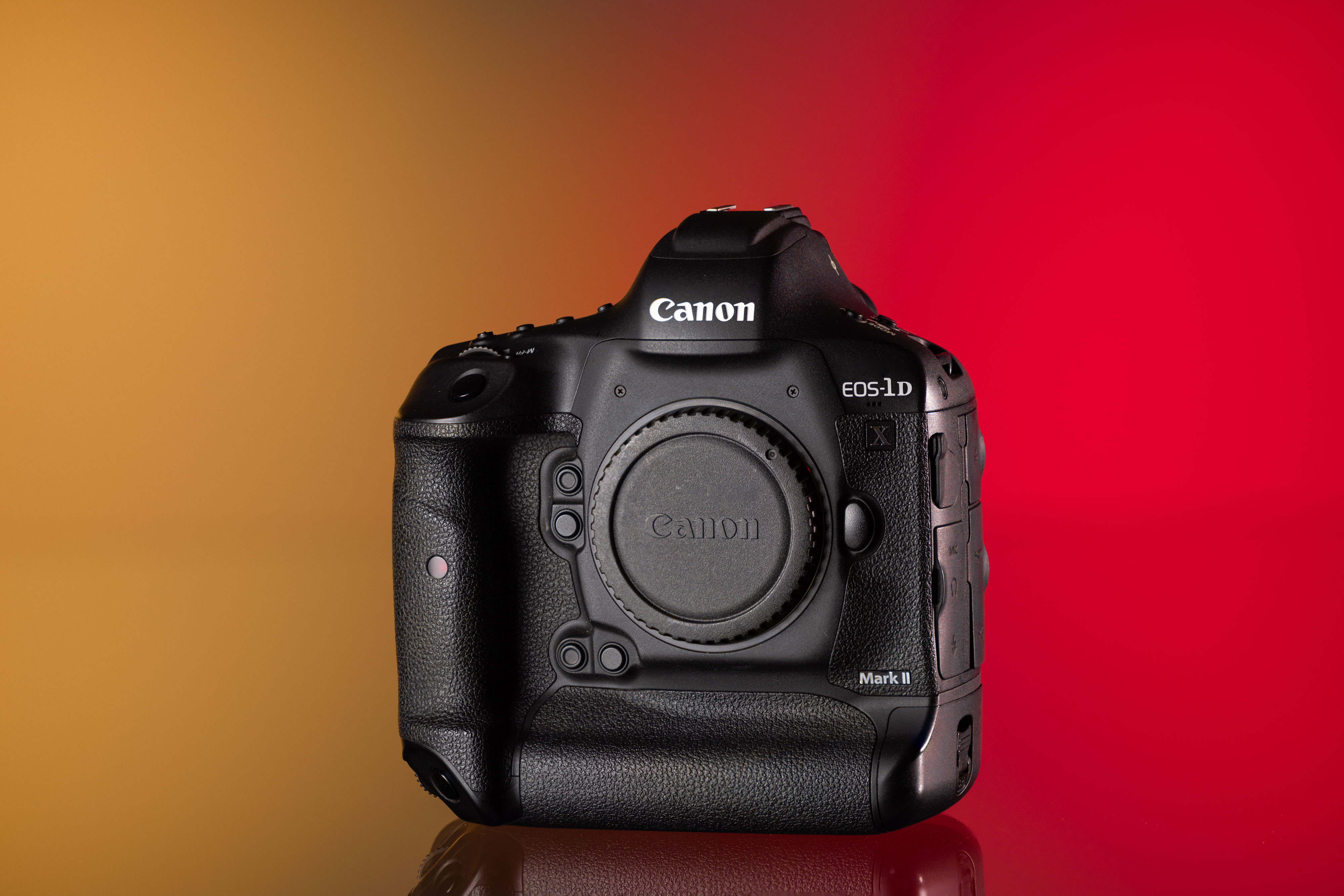 Cámara Canon EOS 1DX Mark II de segunda mano sobre un fondo amarillo y rojo