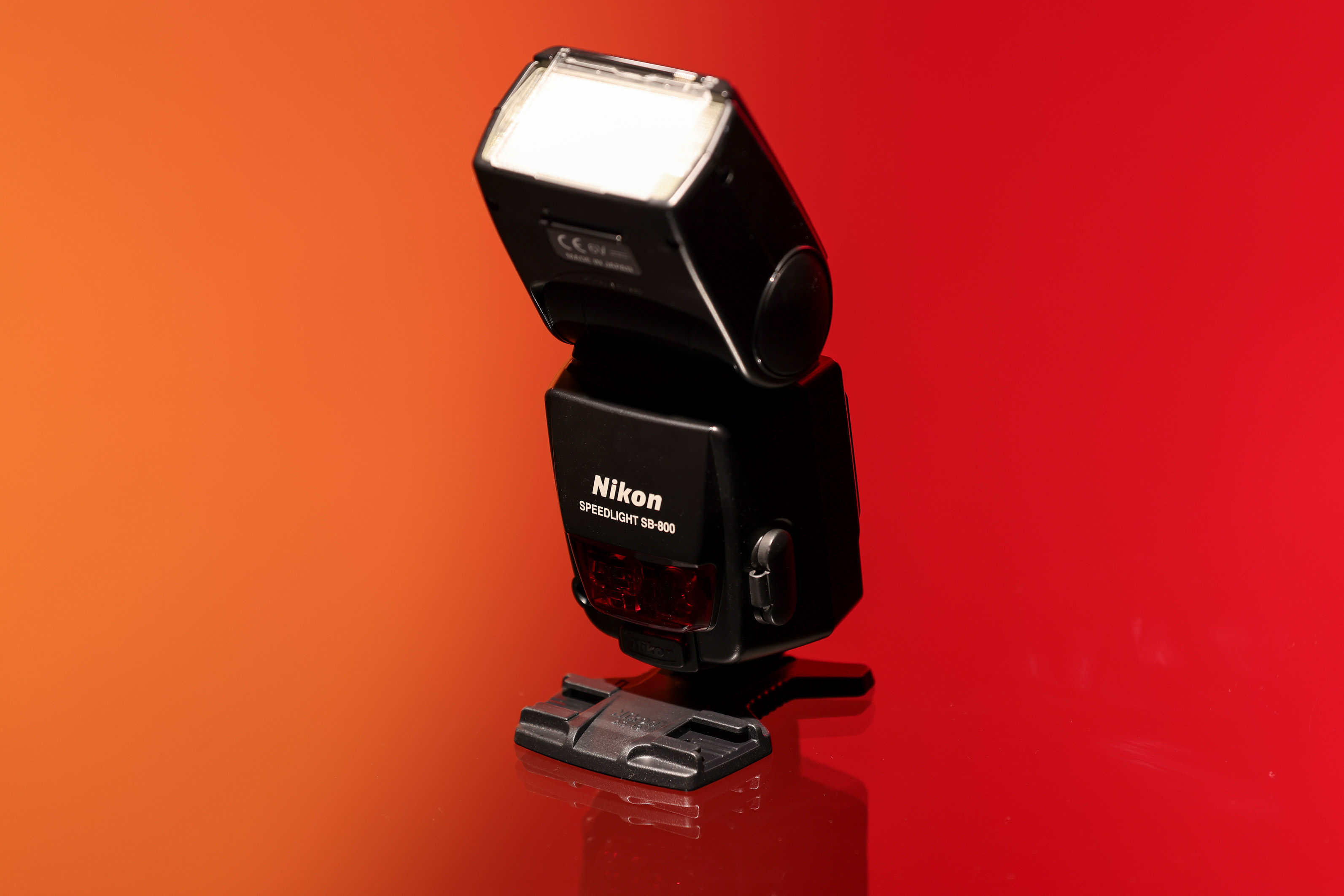 Nikon SB-800 Speedlight against an orange and red background.