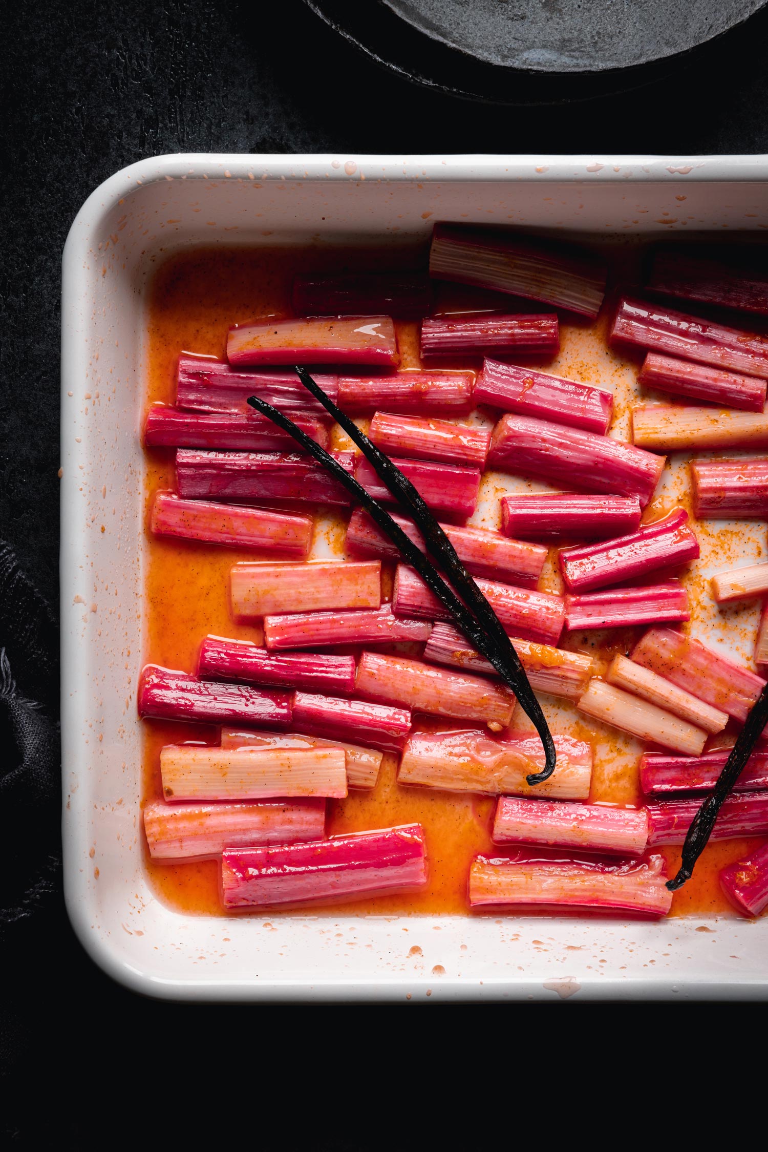 Rhubarbe hachée dans un plat de cuisson avec des gousses de vanille sur le dessus, photographiée par Bea Lubas avec le Canon EOS R5.

