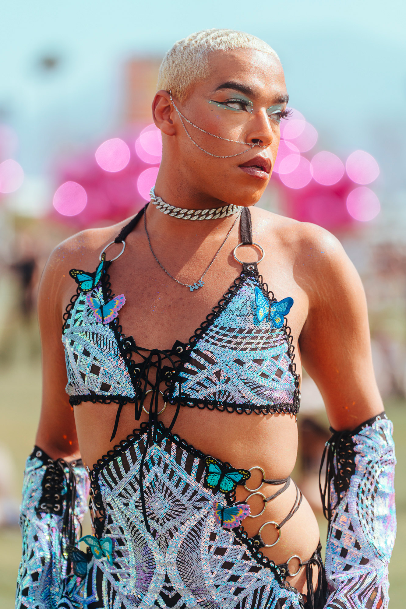 A person with a butterfly outfit and chain at 2023 Coachella Valley Music and Arts Festival.