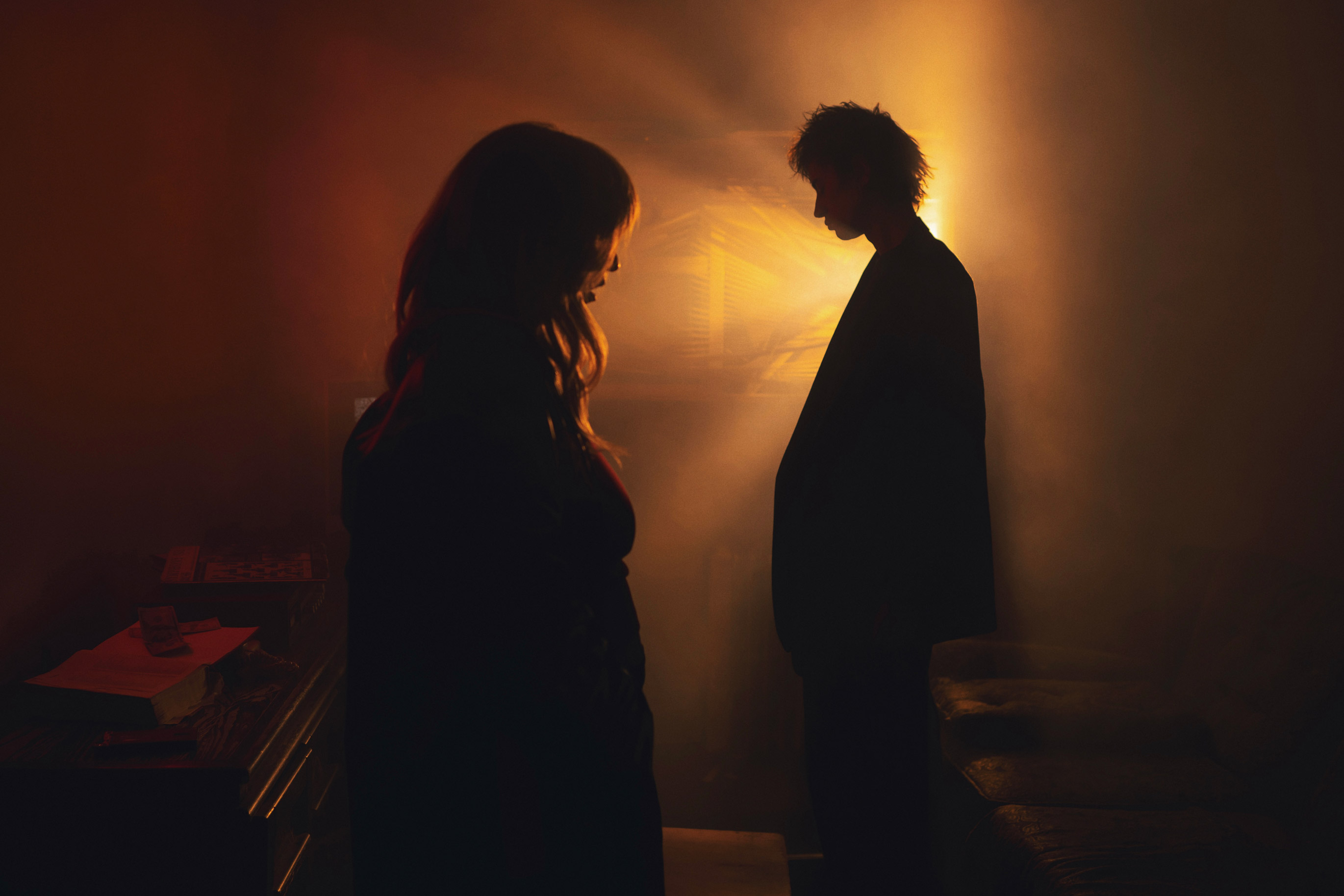 Silhouettes of two people with golden light behind person with short hair, photo by Brandon Woelfel
