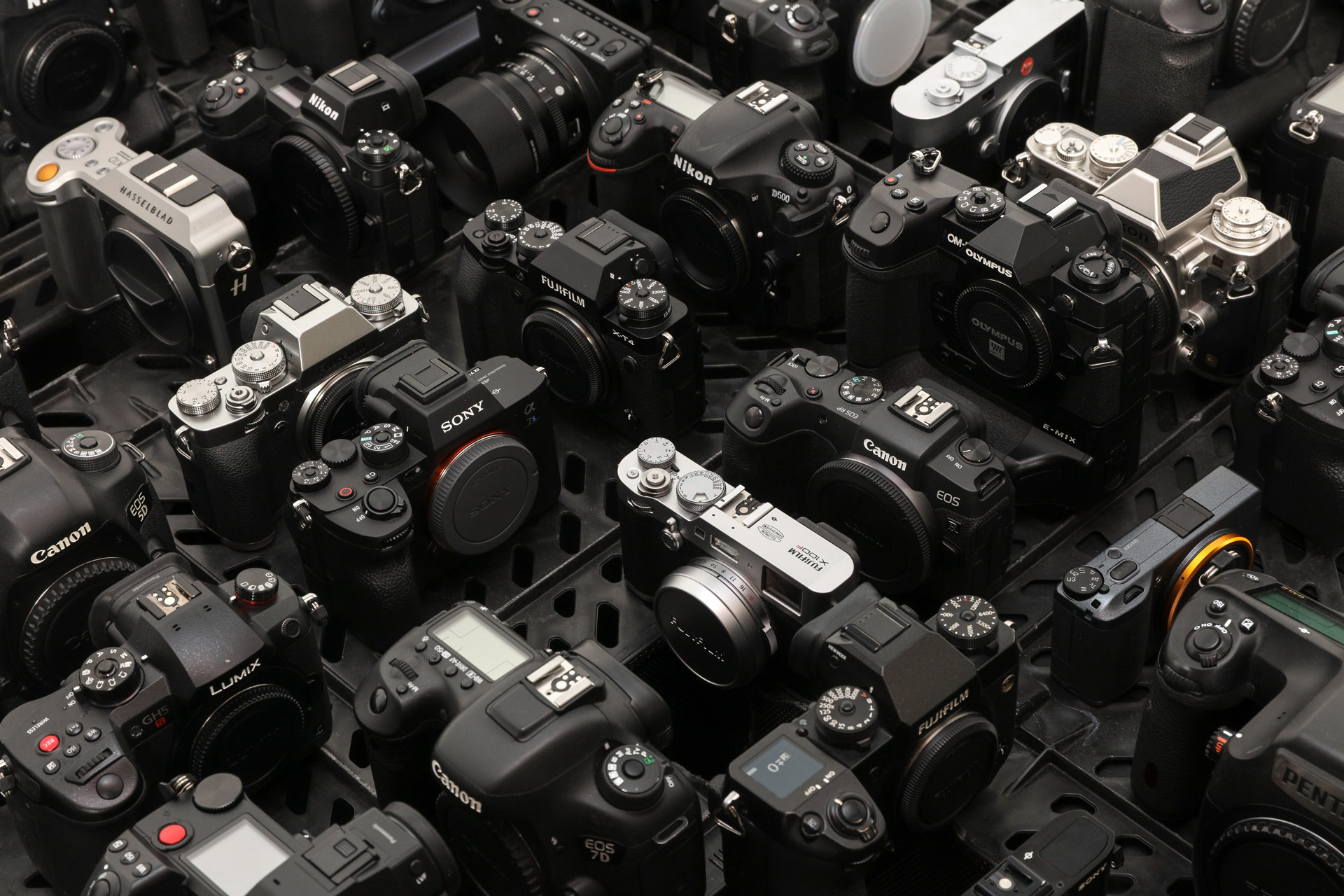 A photo of a large array of used cameras from MPB set against a grey background