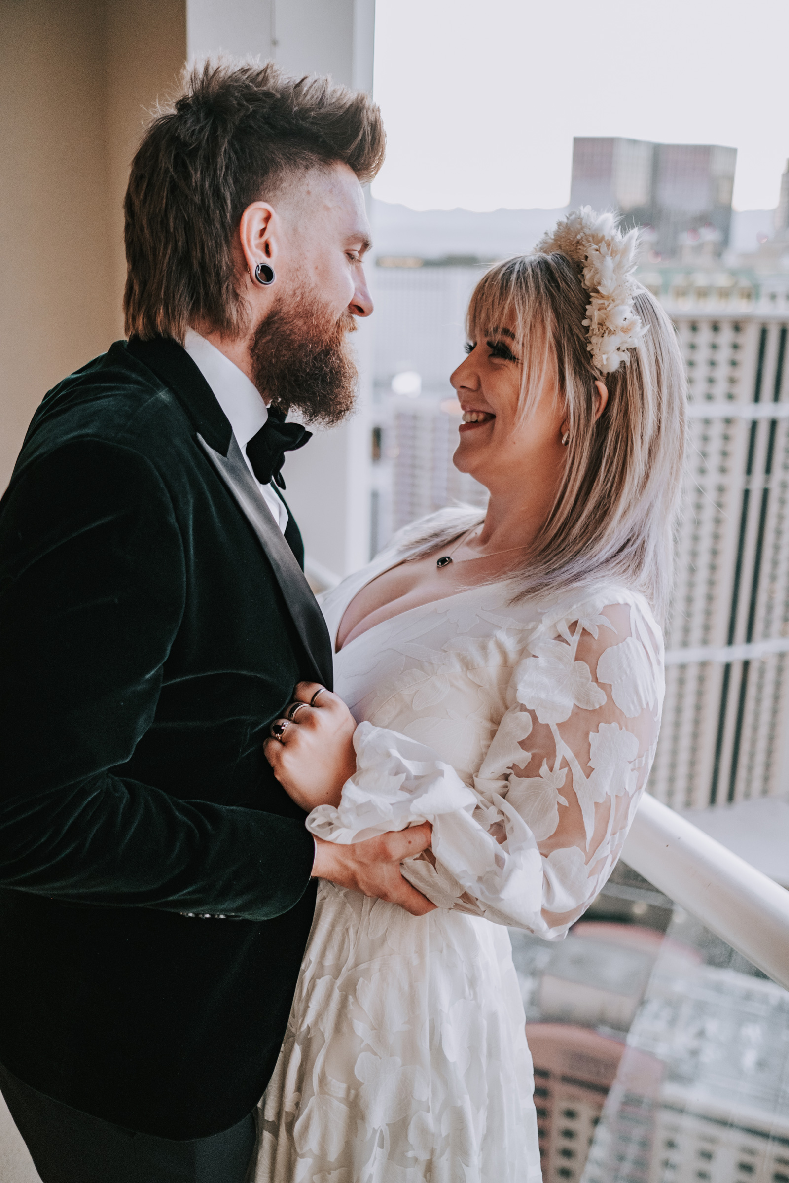 Un couple de mariés se regarde dans les yeux sur le balcon d'un hôtel à Las Vegas, Nevada, photographié par Matthew Palmer avec un Fujifilm X-T4.