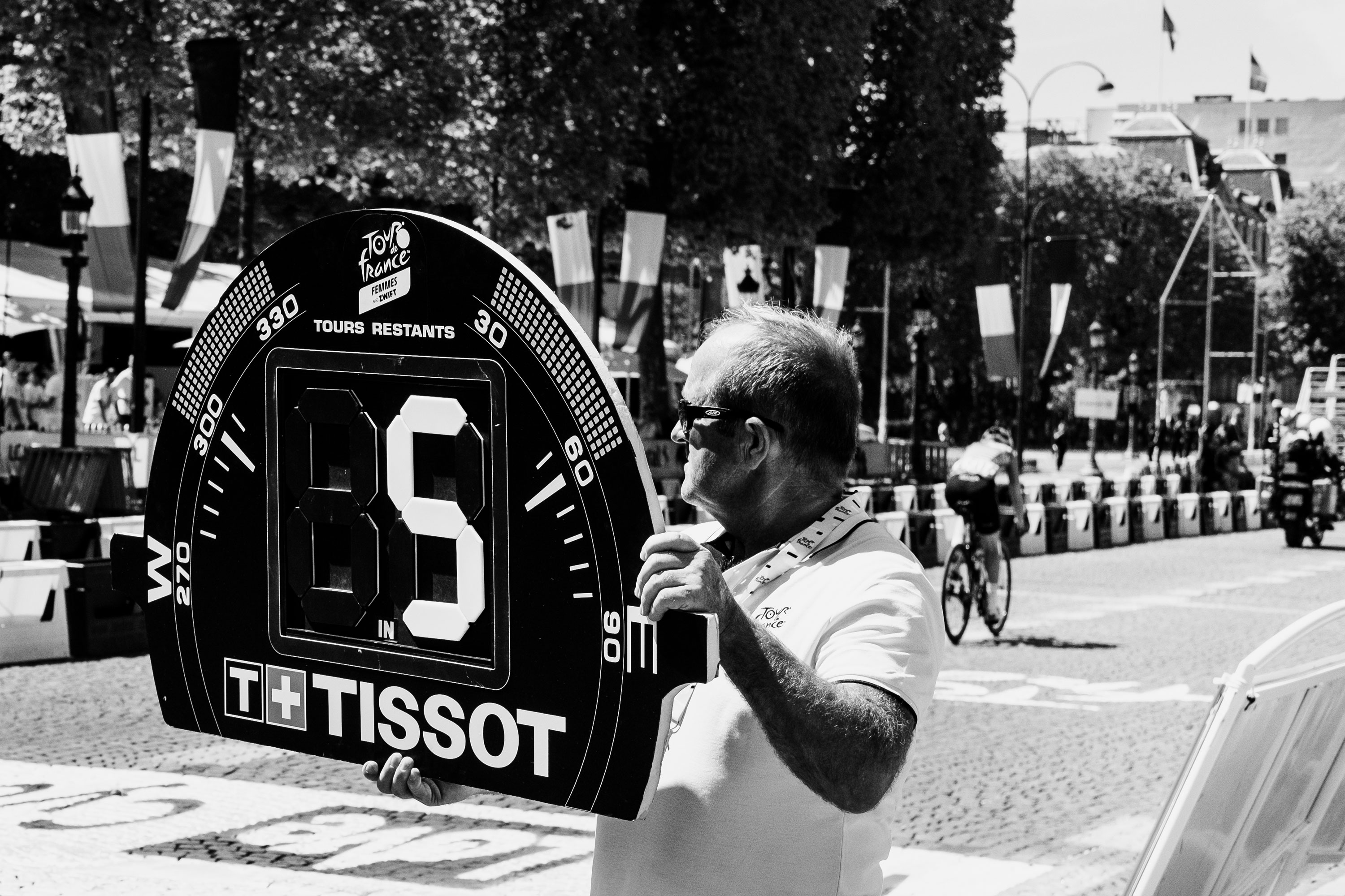 Man holding a board at the Tour De France Women | Leica Q2

