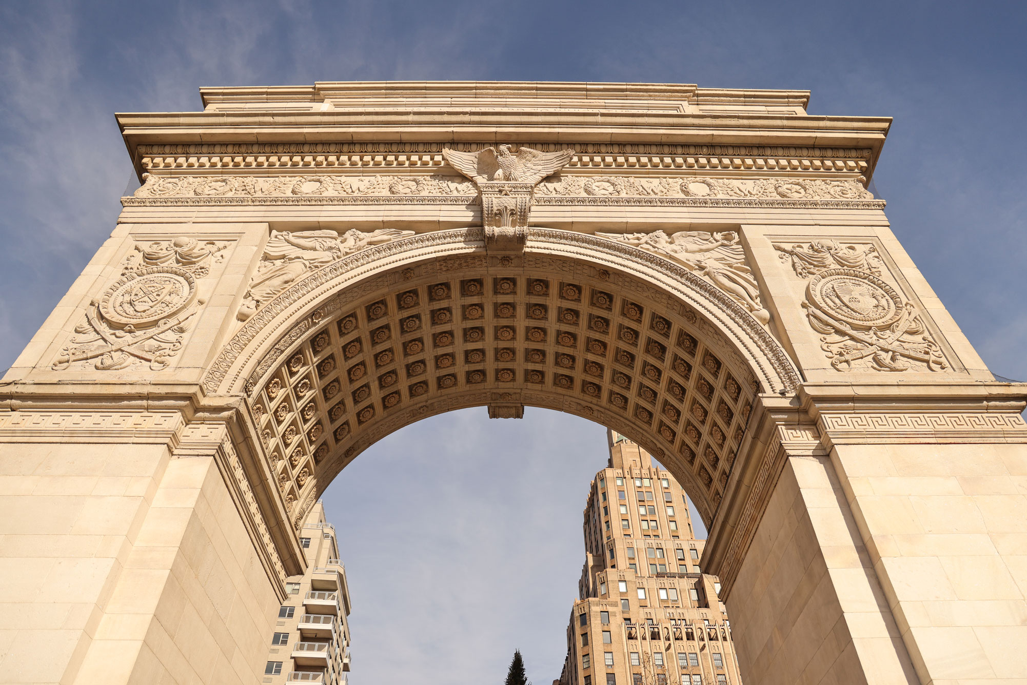 Wide-angle shot of the Washington Arch in Washington Square Park, NYC during the daytime. Photo by Berta Amelinaite.