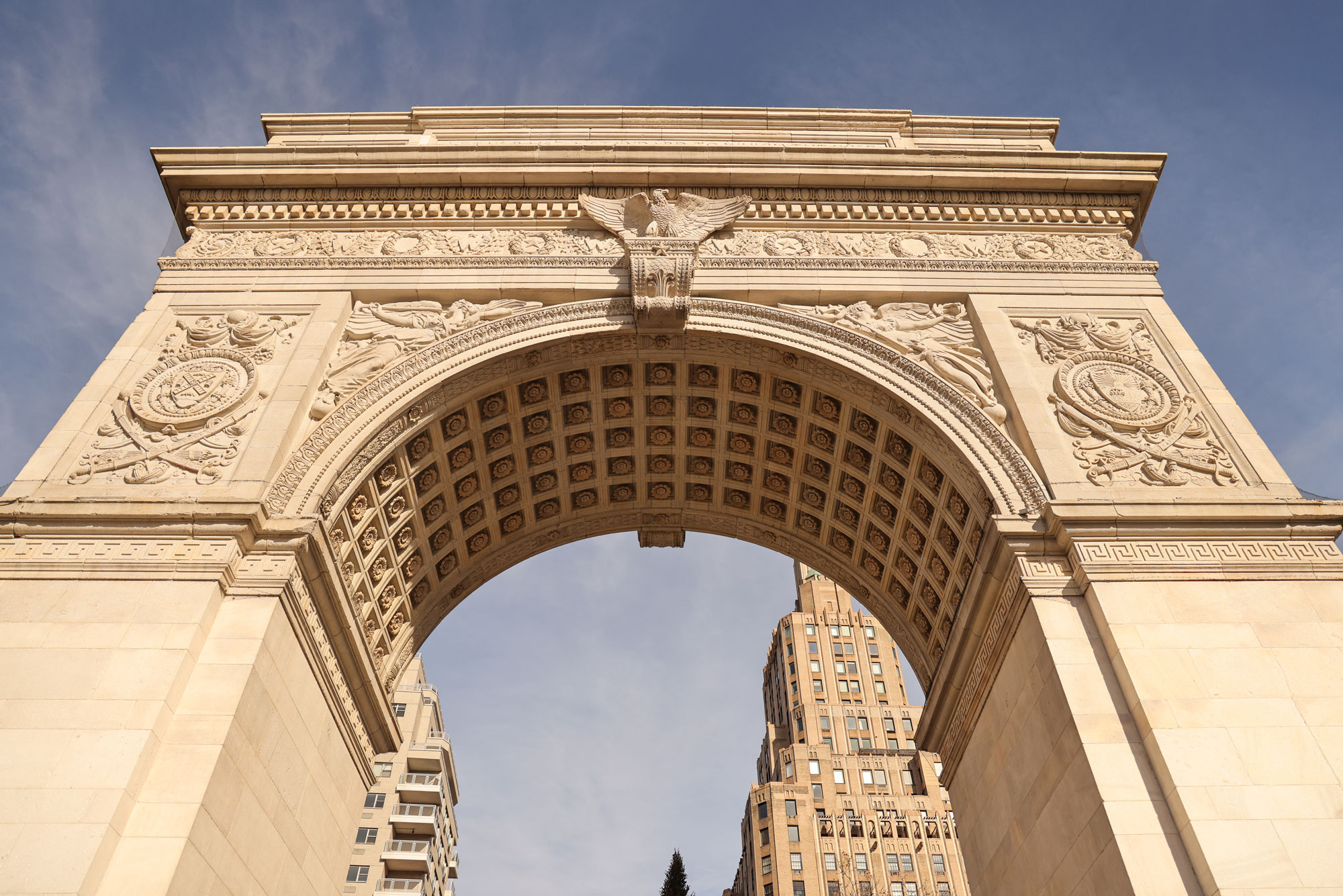 Weitwinkelaufnahme des Washington Arch im Washington Square Park, NYC, bei Tageslicht.