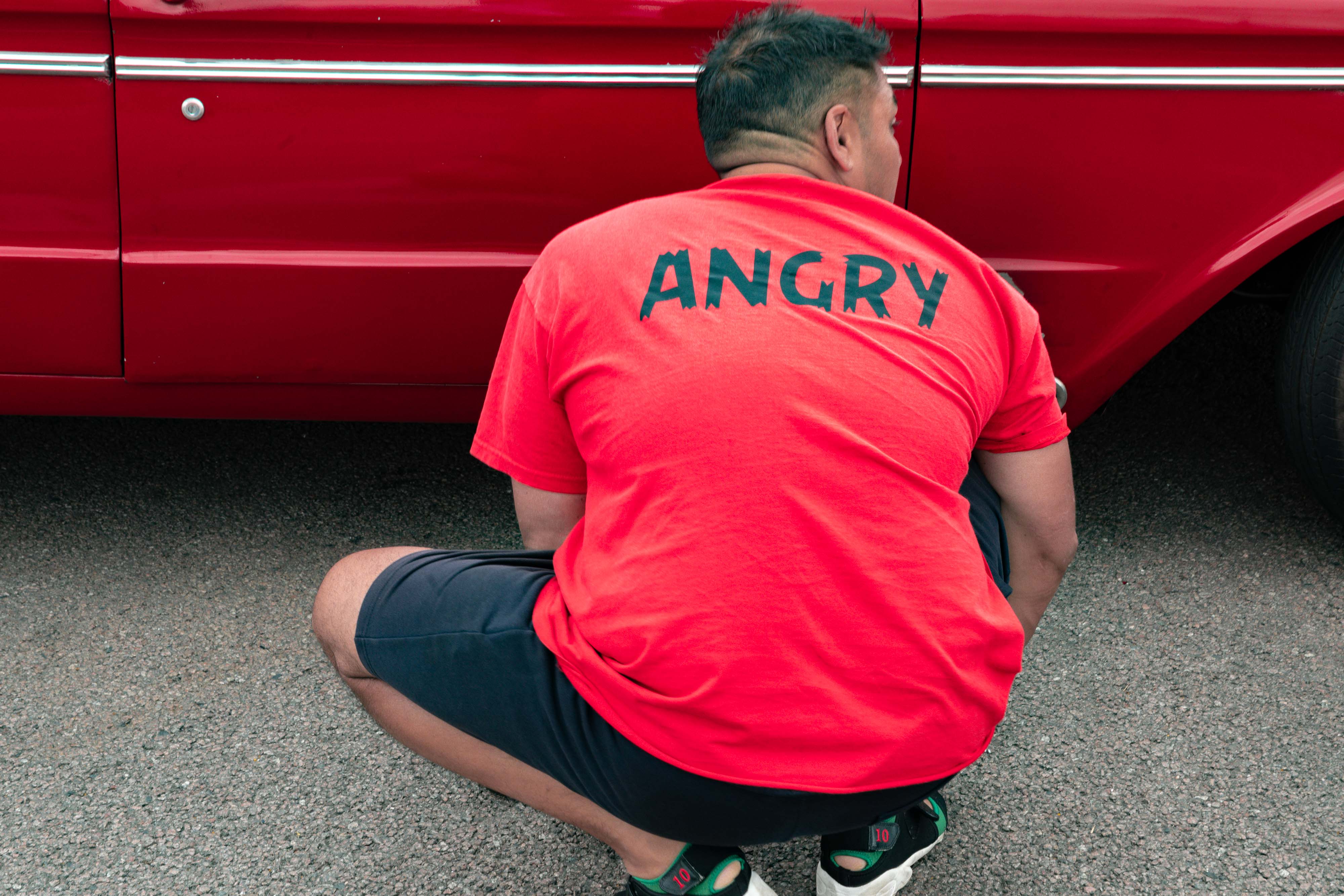 A person wearing a t-shirt that says 'angry'