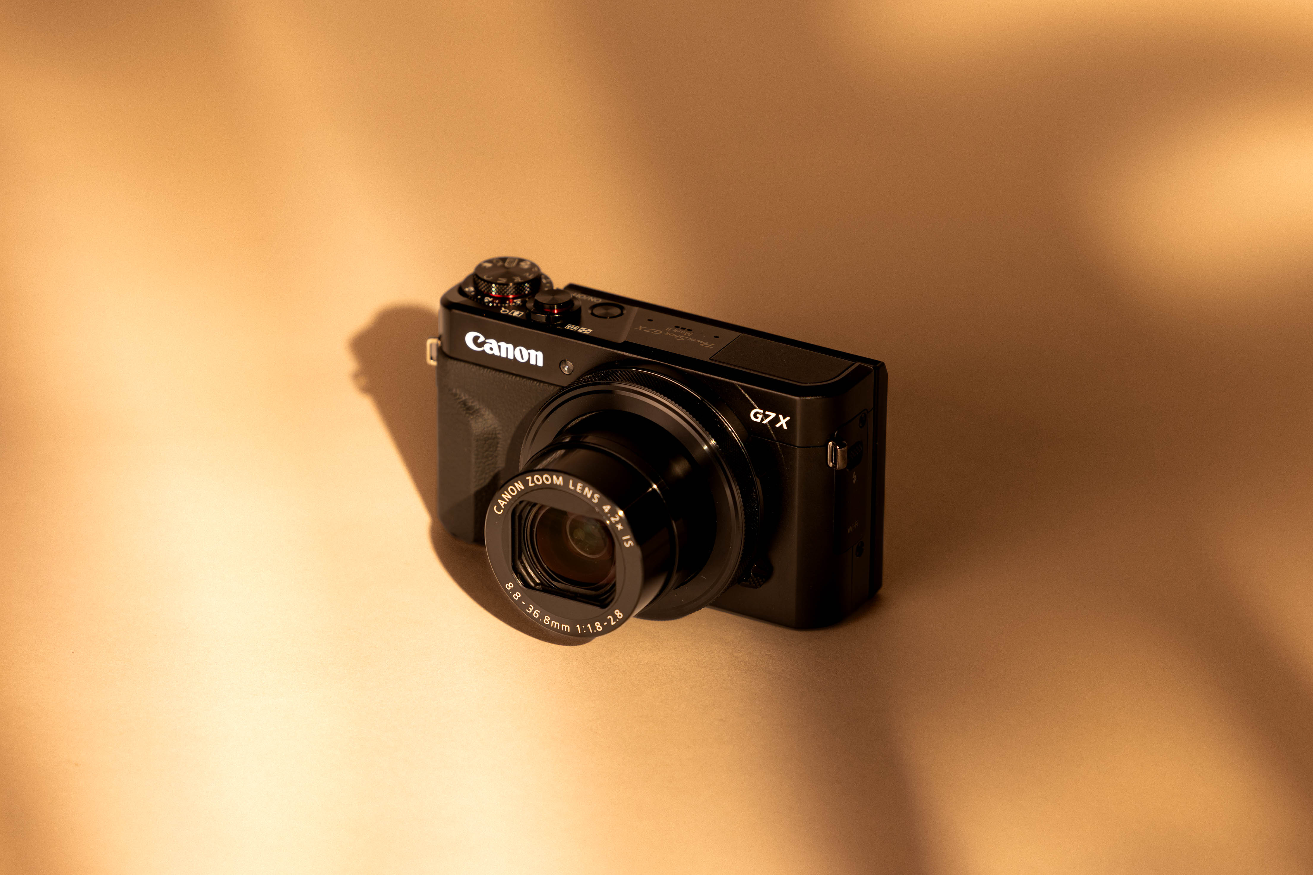 Canon G7X III auf cremefarbenem Hintergrund