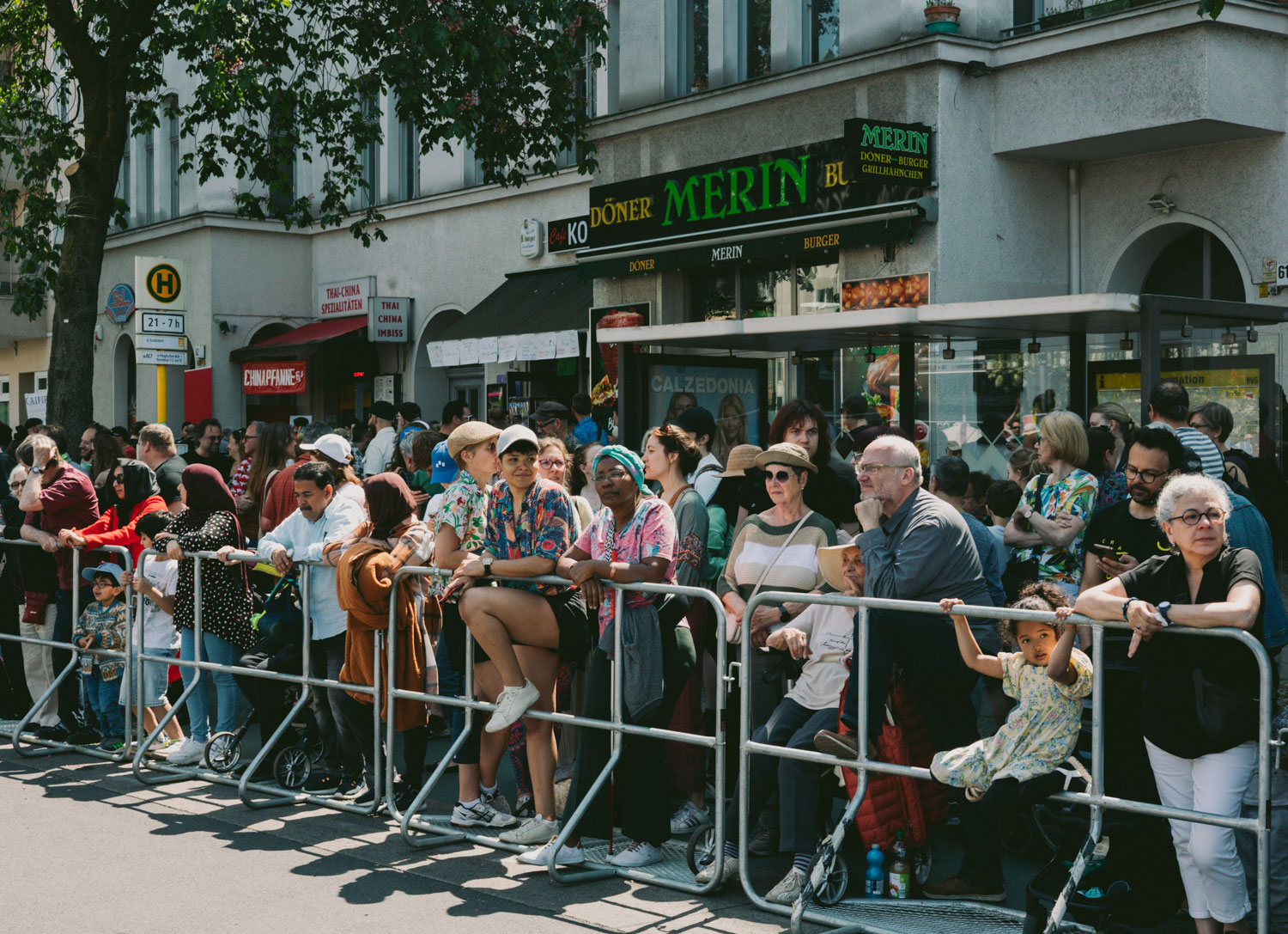People stand lined up at a barrier waiting, shot by Stefanie Schmid Rincon with the Canon EOS R6