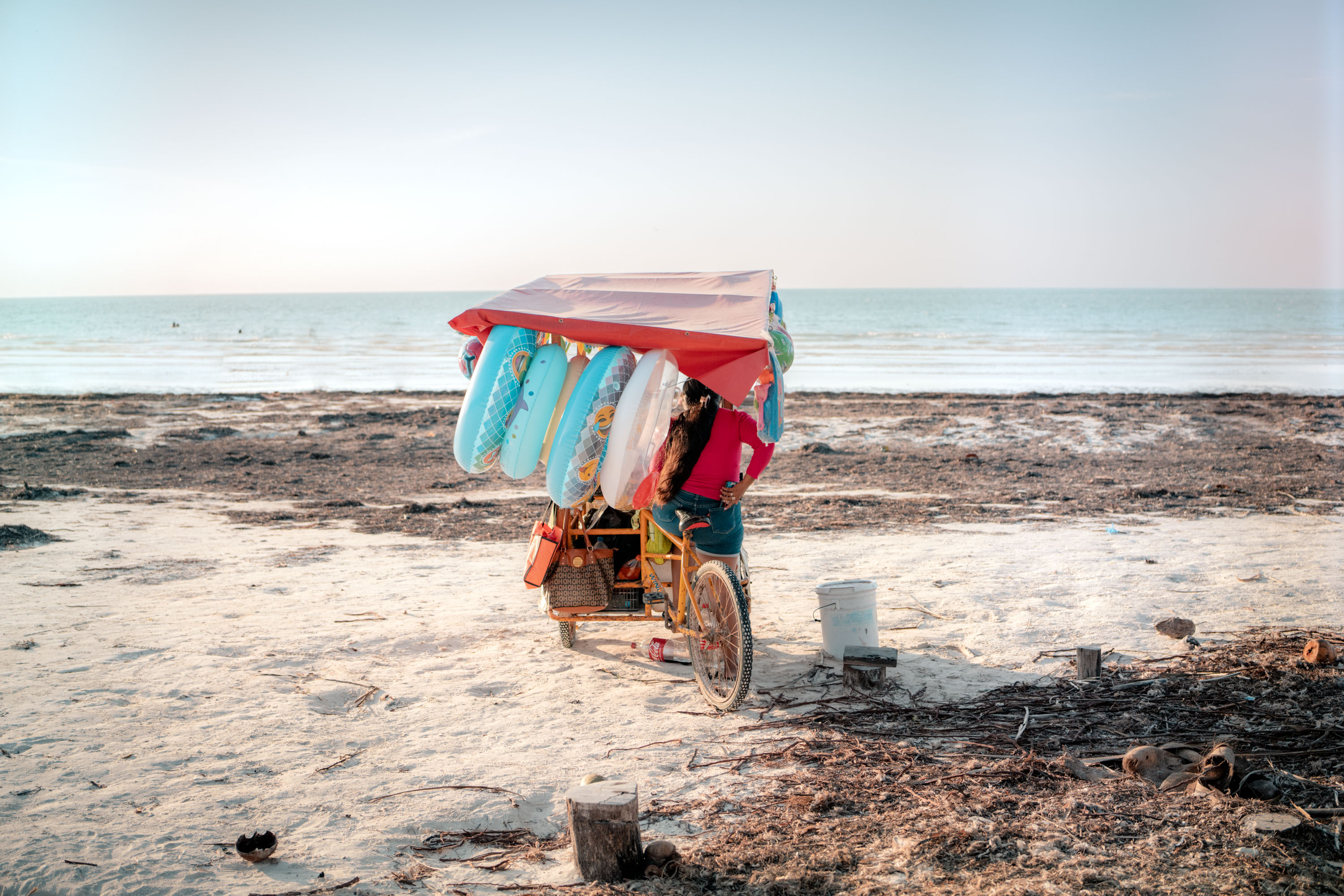 A person selling rubber dingings on the beach on a bright sunny day in Mexico. By Ian Howorth.