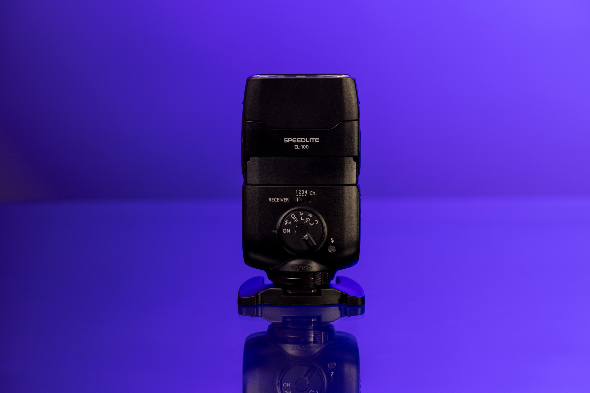 Canon EL-100 Speedlite vor einem violetten Hintergrund.
