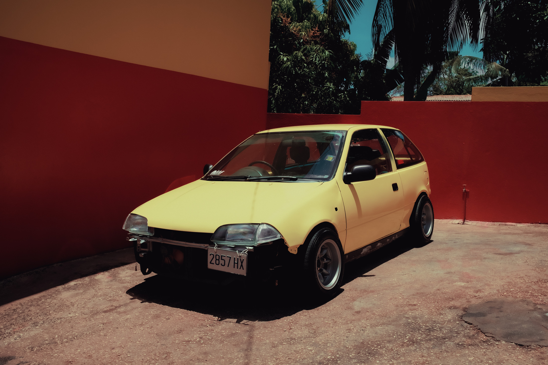 A yellow car on a driveway in Jamaica
