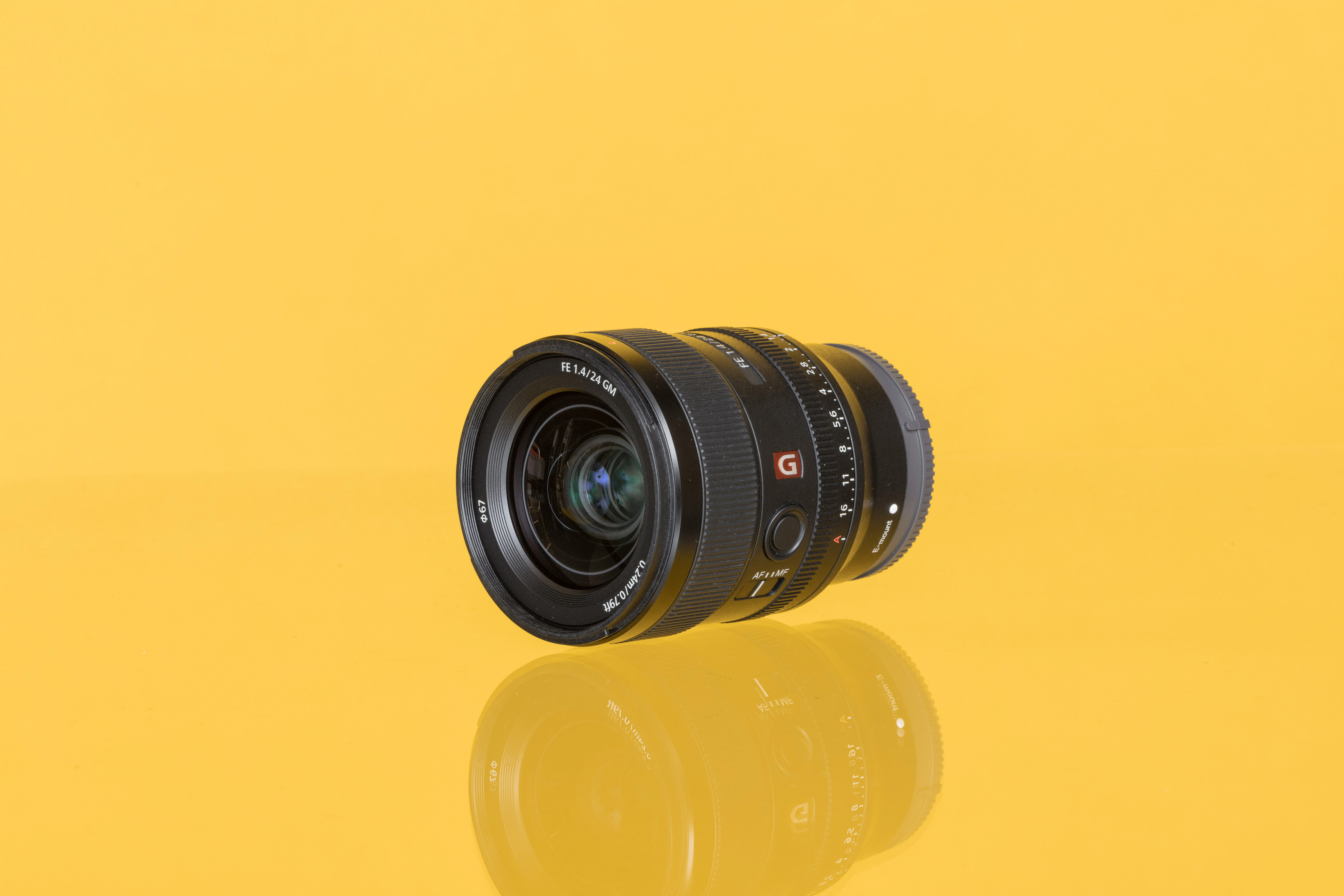 A used Sony FE 24mm f/1.4 GM from MPB against a yellow background