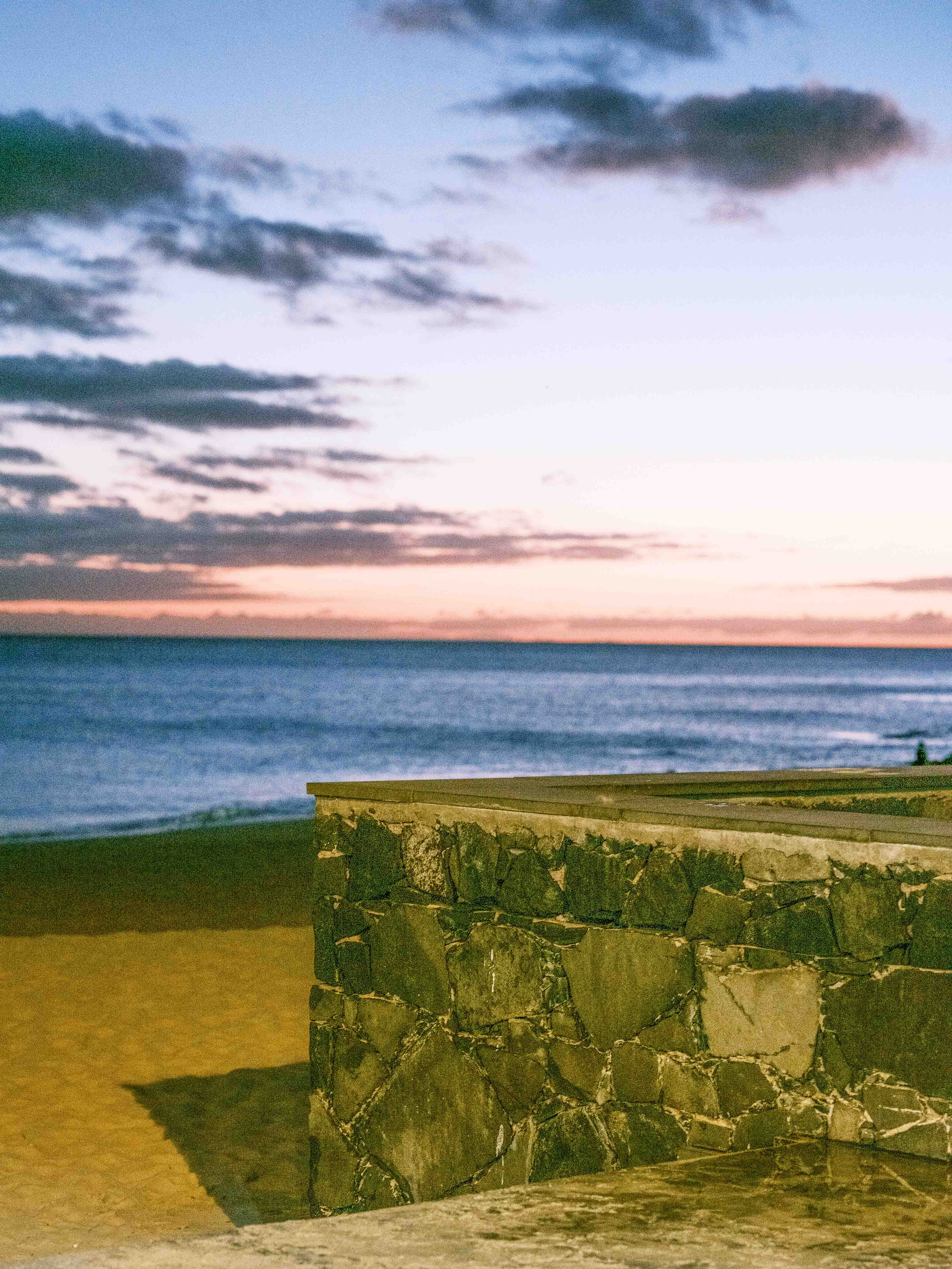 Image of a sunset on the beach with a promenade wall in the foreground with the shadows pushed +100 and exposure pushed +1 stop in Lightroom. Taken on the Fujifilm GFX 50R by Connor Redmond.
