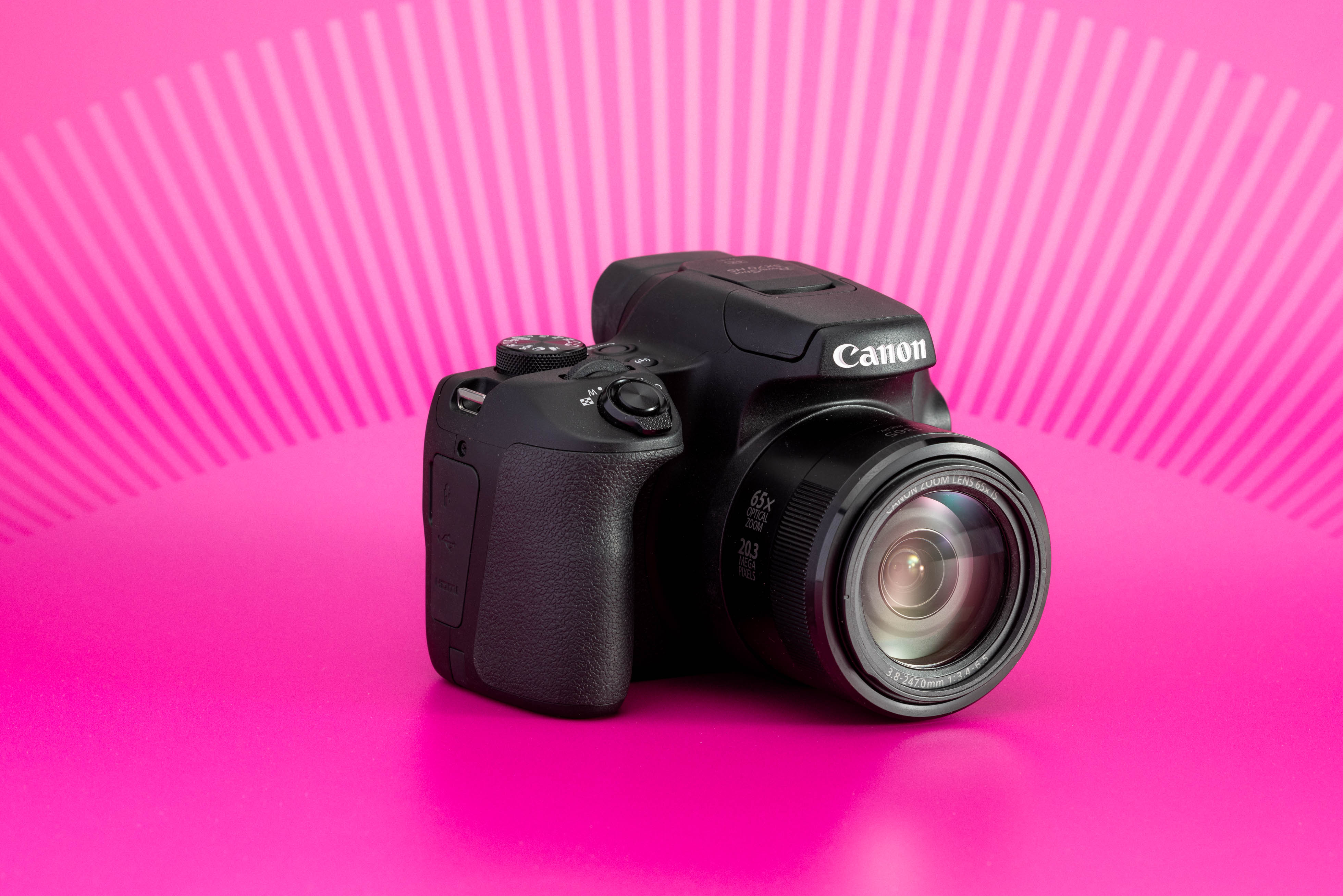 Canon PowerShot SX70 HS con objetivo zoom integrado sobre fondo rosa. Foto de Connor Redmond