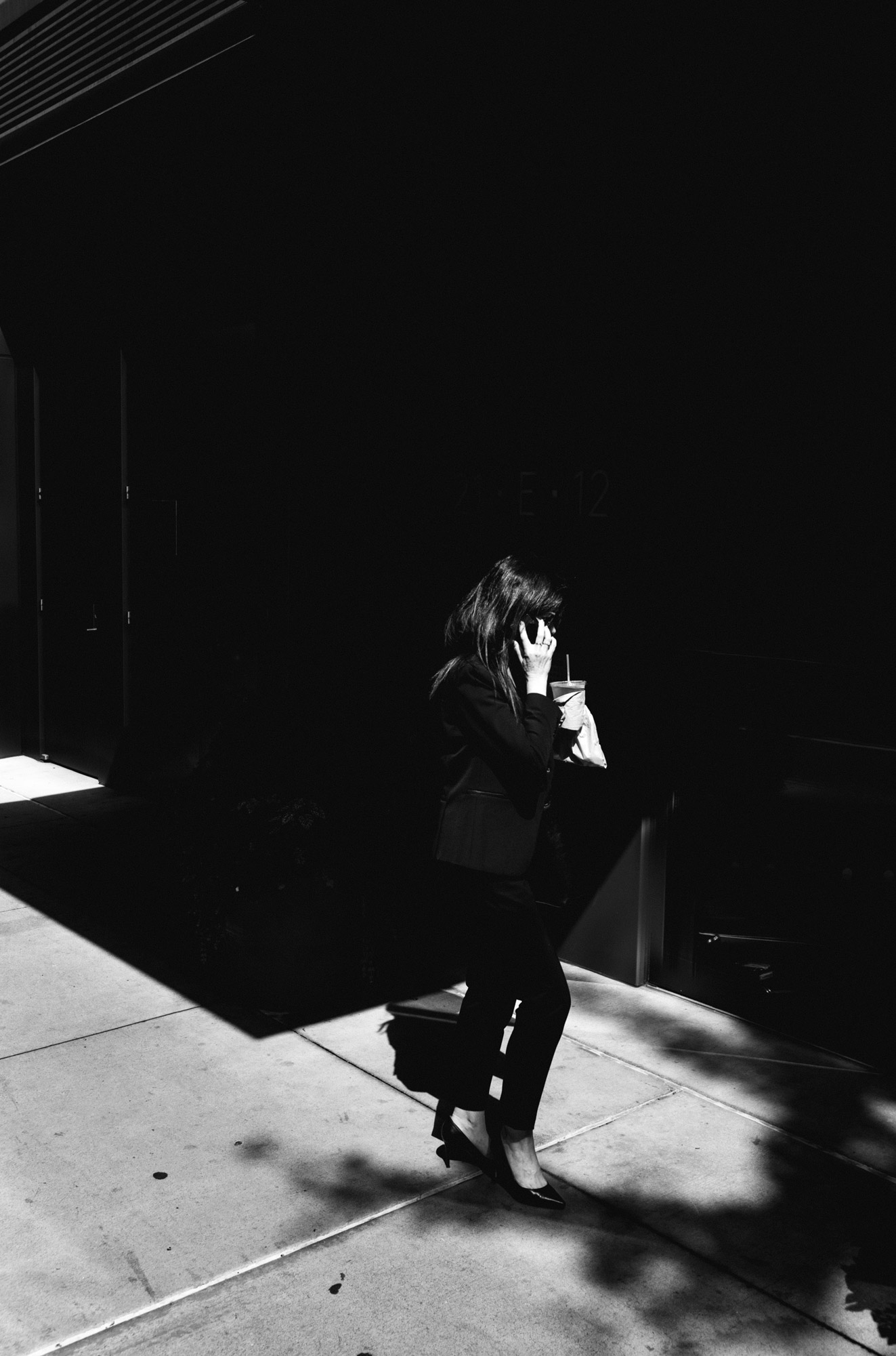A black-and-white photo of a person in high heels talking on a cell phone