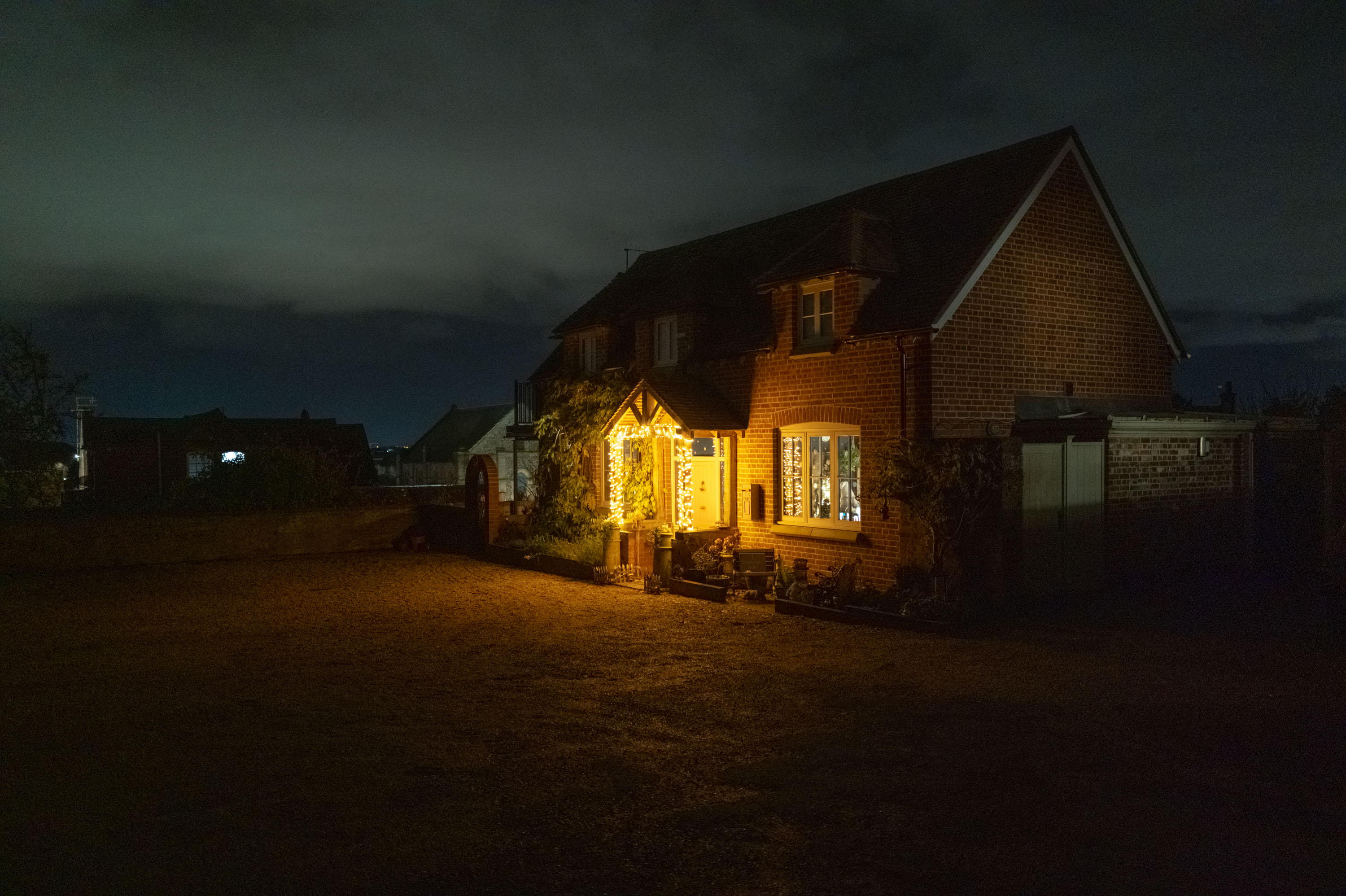 Maison de nuit, avec des lumières vives autour de la porte d’entrée. ISO 6400.
