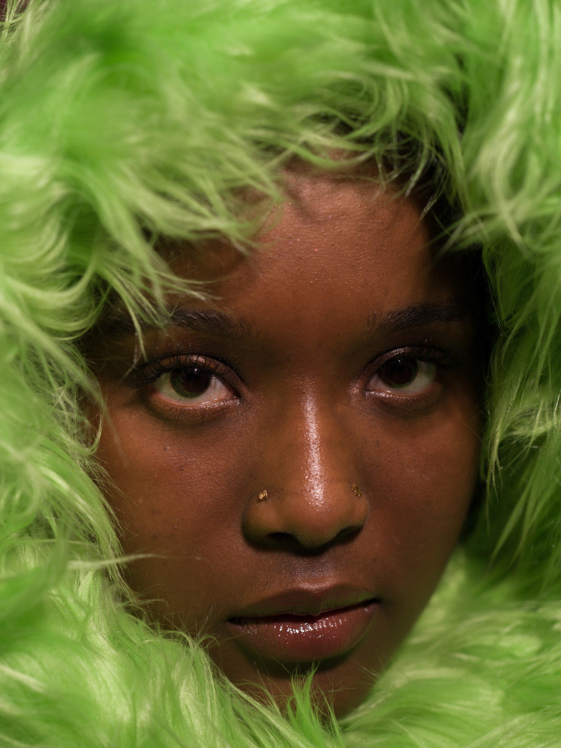 Portrait of a person with green fuzzy material using butterfly lighting technique. Photo by Kaylah Sambo on a Hasselblad X1D-50c.