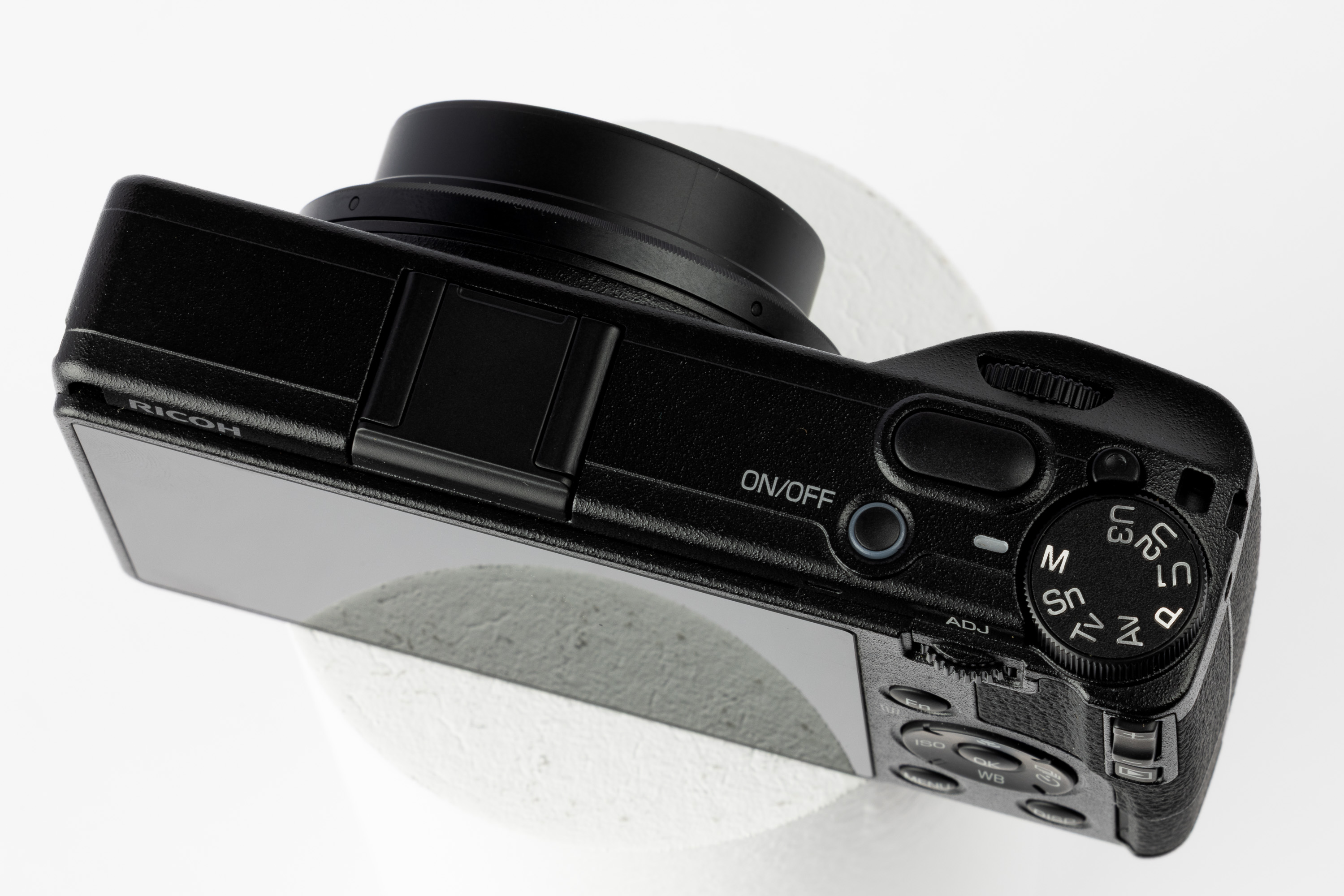 Blick auf die Einstellräder, den Blitzschuh und das Display der Ricoh GR IV von oben