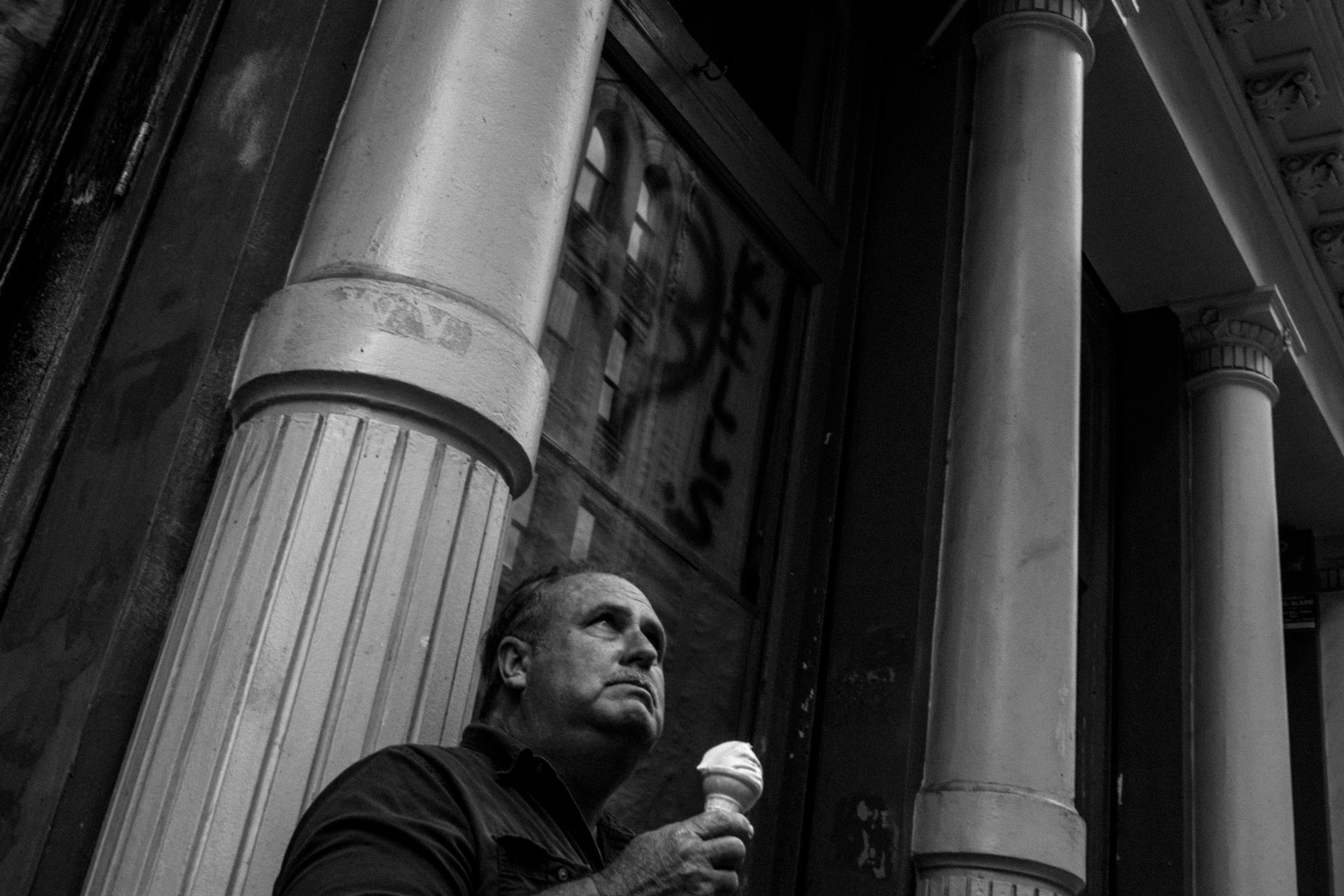 A black-and-white photo of a person holding an ice cream cone