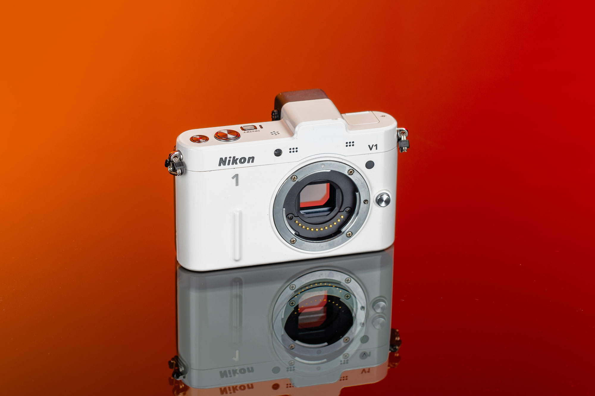Gebrauchte Nikon 1 V1 auf rot-orangefarbenem Hintergrund