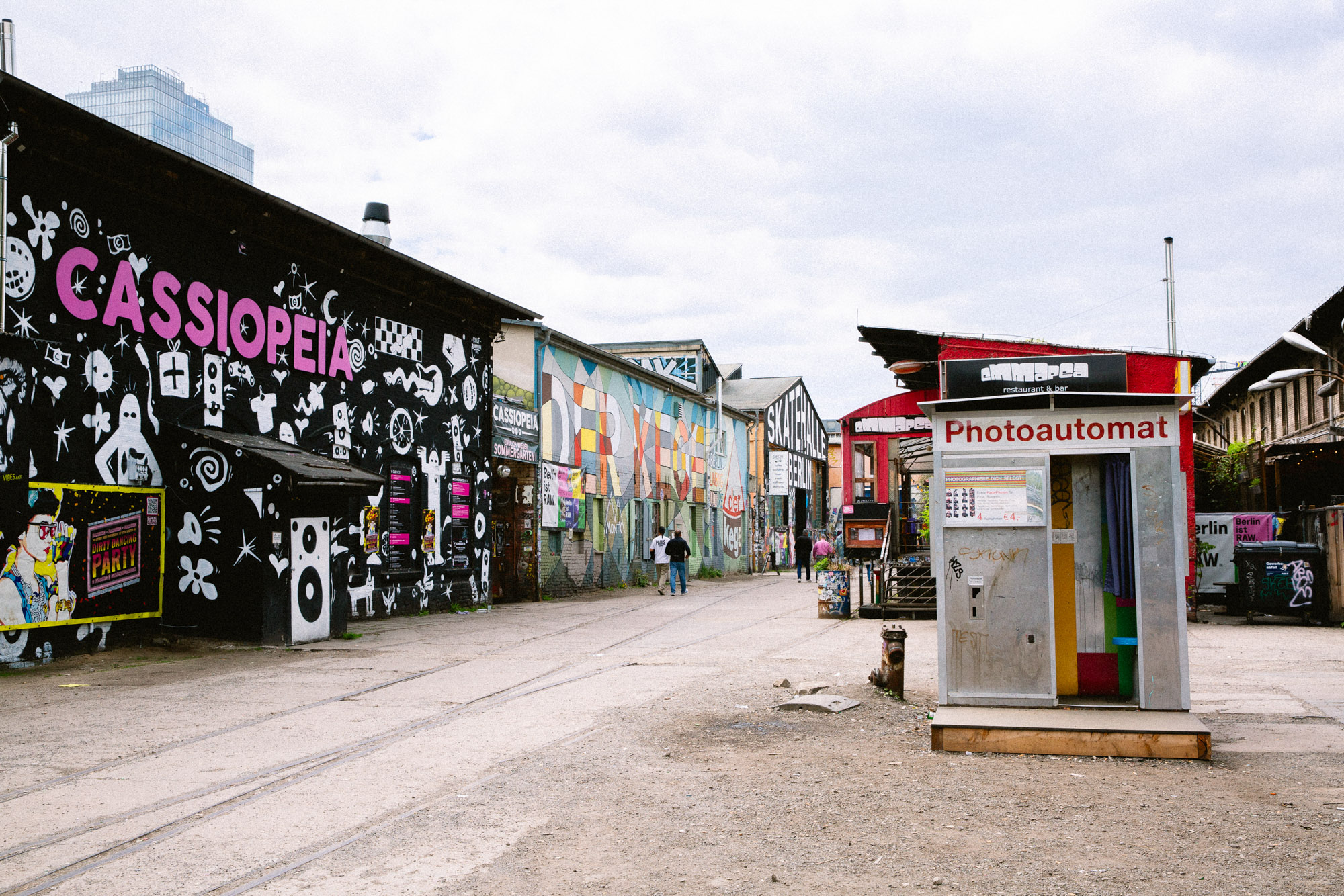 Photograph of Berlin’s RAW-Gelände, with bold street art, a photo booth and graffiti-covered buildings lining an industrial courtyard. Shot by Austin Fassino on a Canon EOS 5D Mark III.