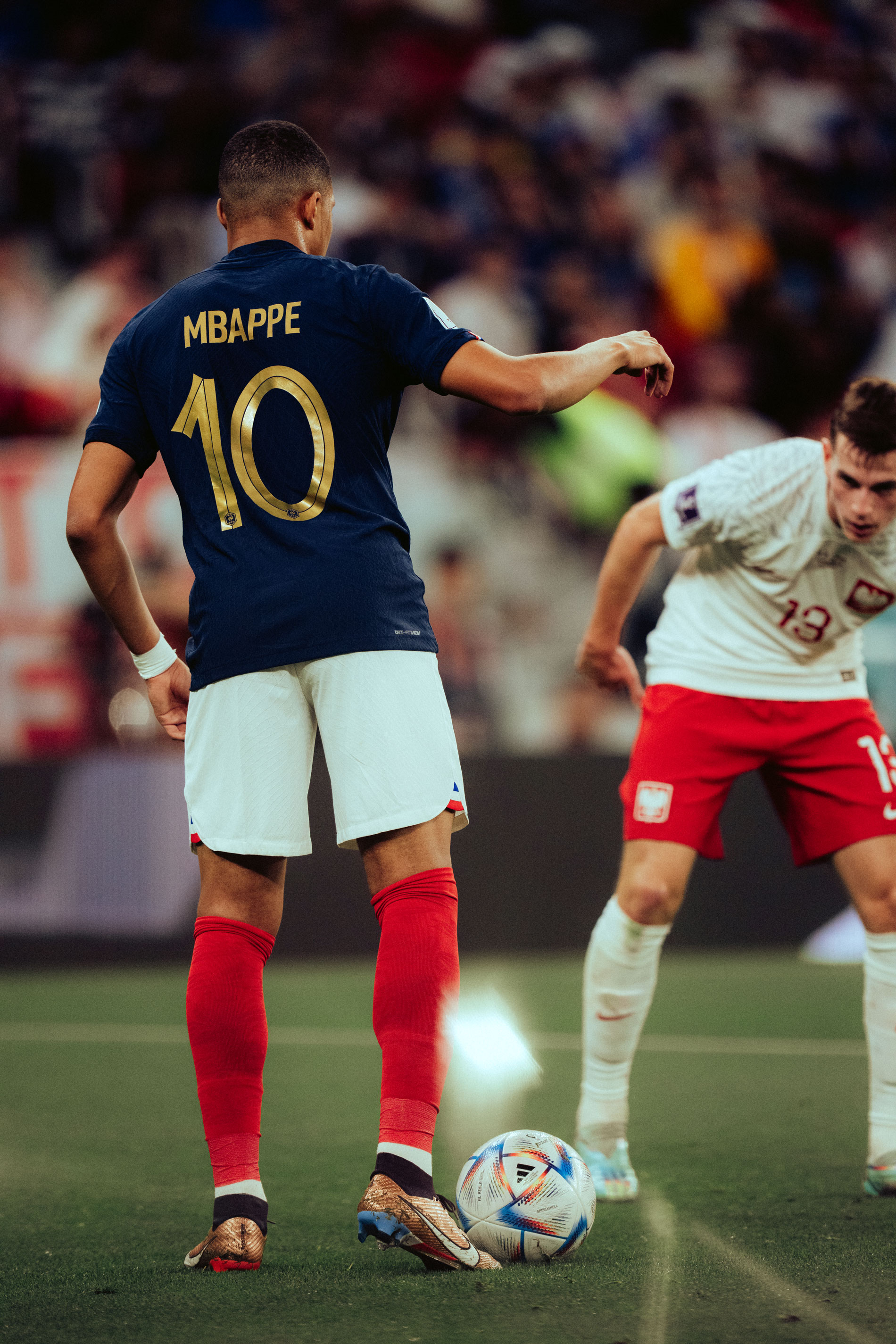 Kylian Mbappé von hinten fotografiert, wie er einem gegnerischer Spieler gegenübersteht, aufgenommen von Lukas Mengeler