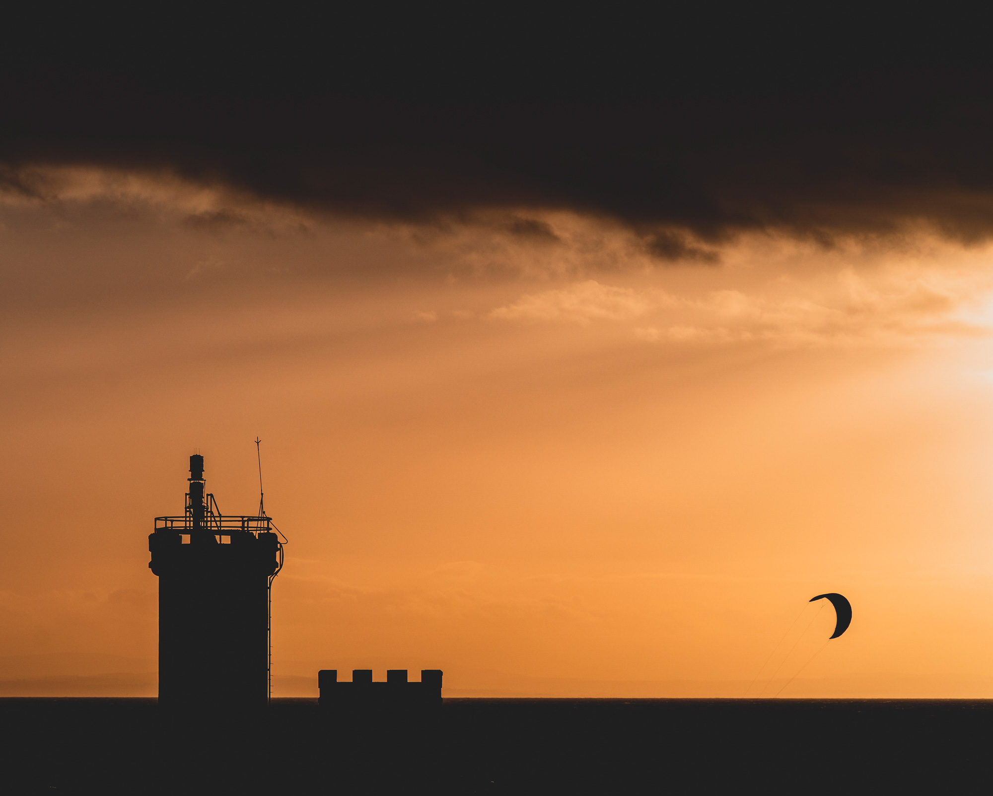 Silhouette eines Lenkdrachens und Umrisse von Gebäuden links davon, aufgenommen von Scott Jessiman mit einer Nikon Z6 II

