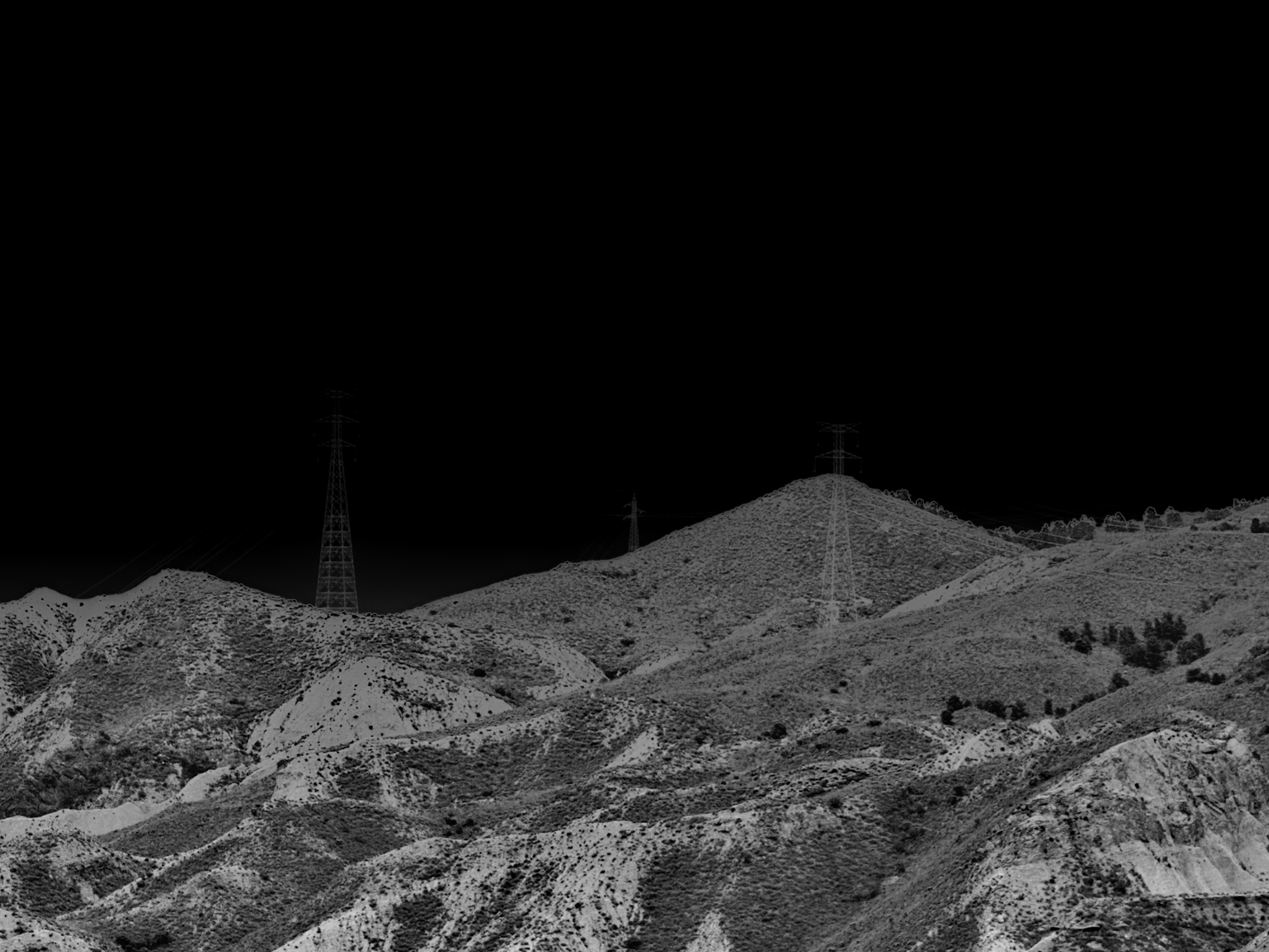 Black and white photo landscape desert photo with telephone towers on a hill