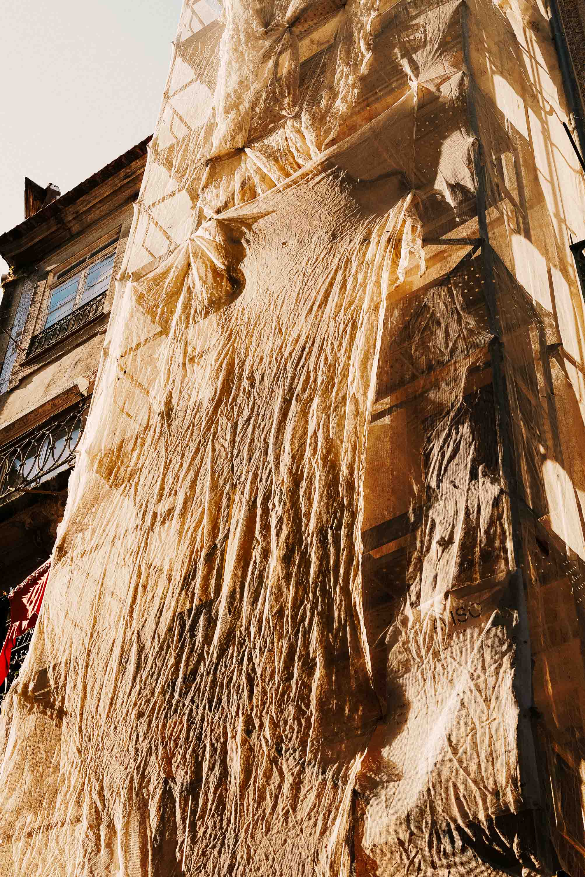 Un échafaudage recouvert d’une bâche en papier ou en plastique, illuminé par le soleil, révélant une texture intéressante. Photo prise avec le Sigma BF par Connor Redmond.