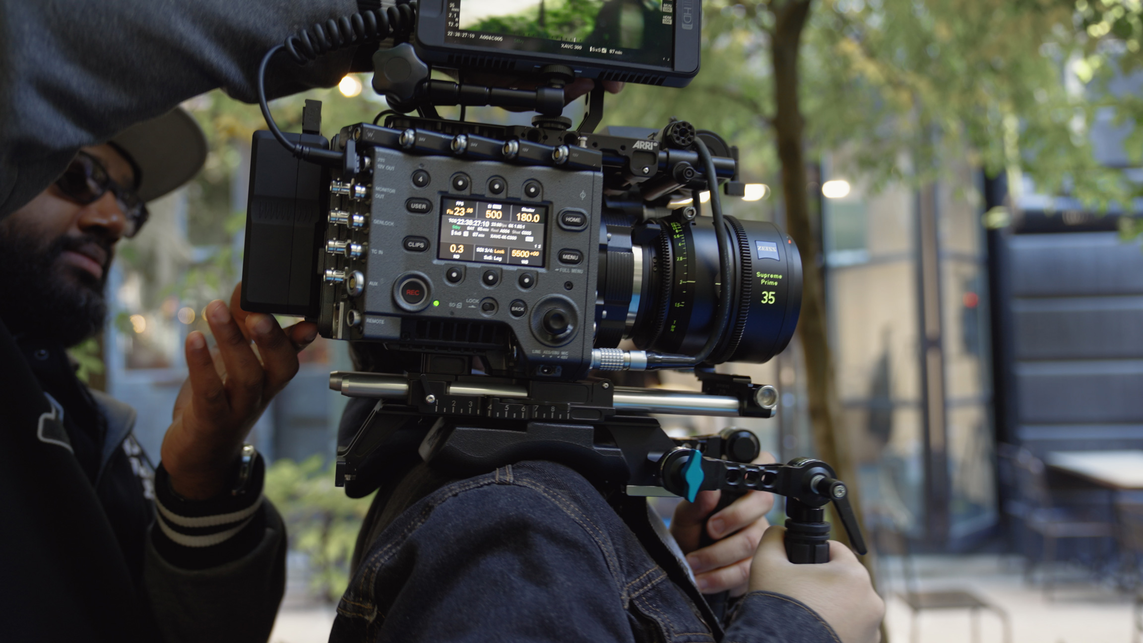 Person helping lift Sony VENICE onto videographers shoulder