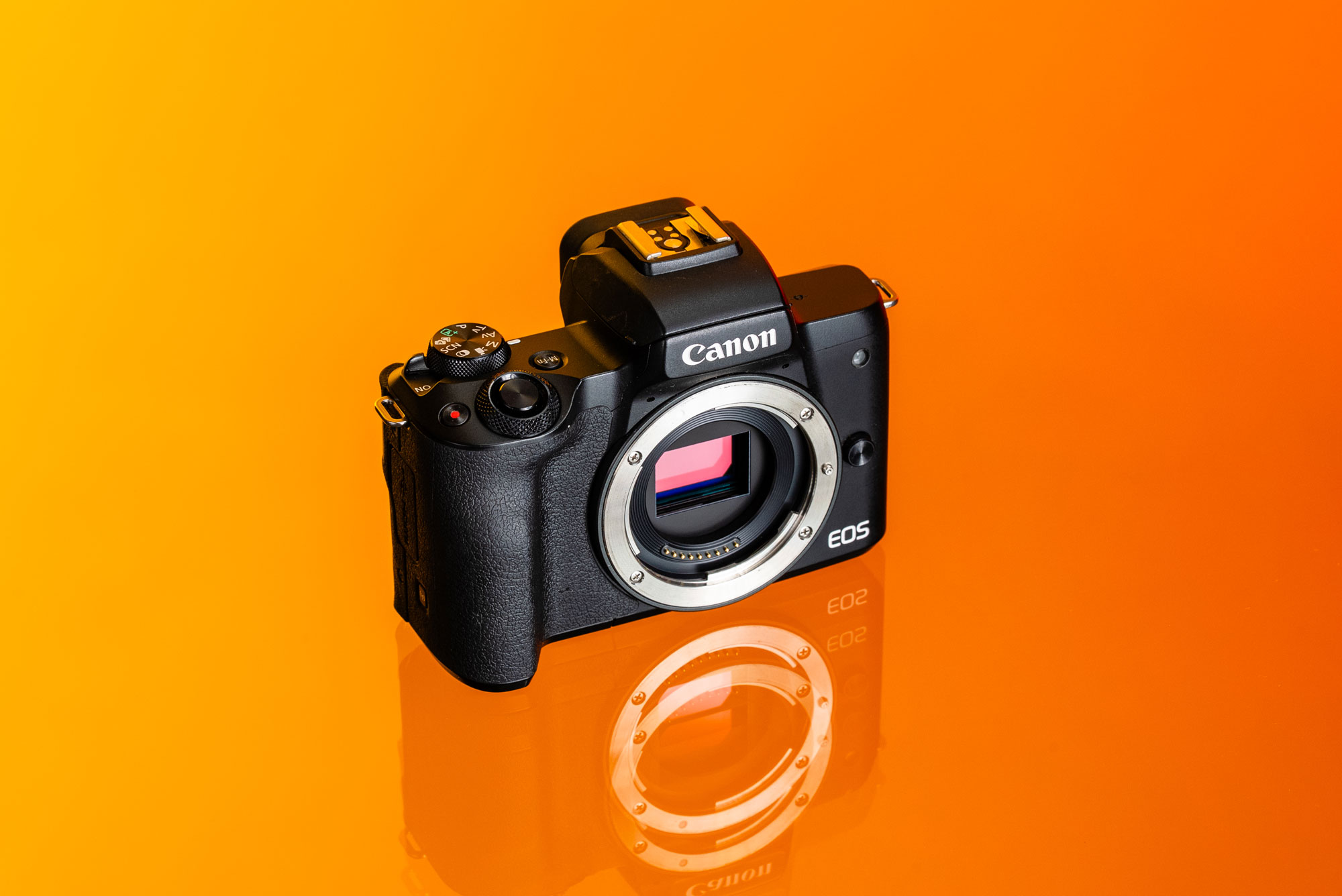Gebrauchte Canon M50 Mark II auf orangem Hintergrund.