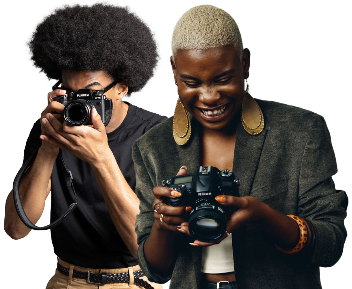 Zwei nebeneinander stehende Personen: Eine schaut durch den Sucher einer Fujifilm-Kamera, die andere blickt auf ihre Nikon-DSLR-Kamera.