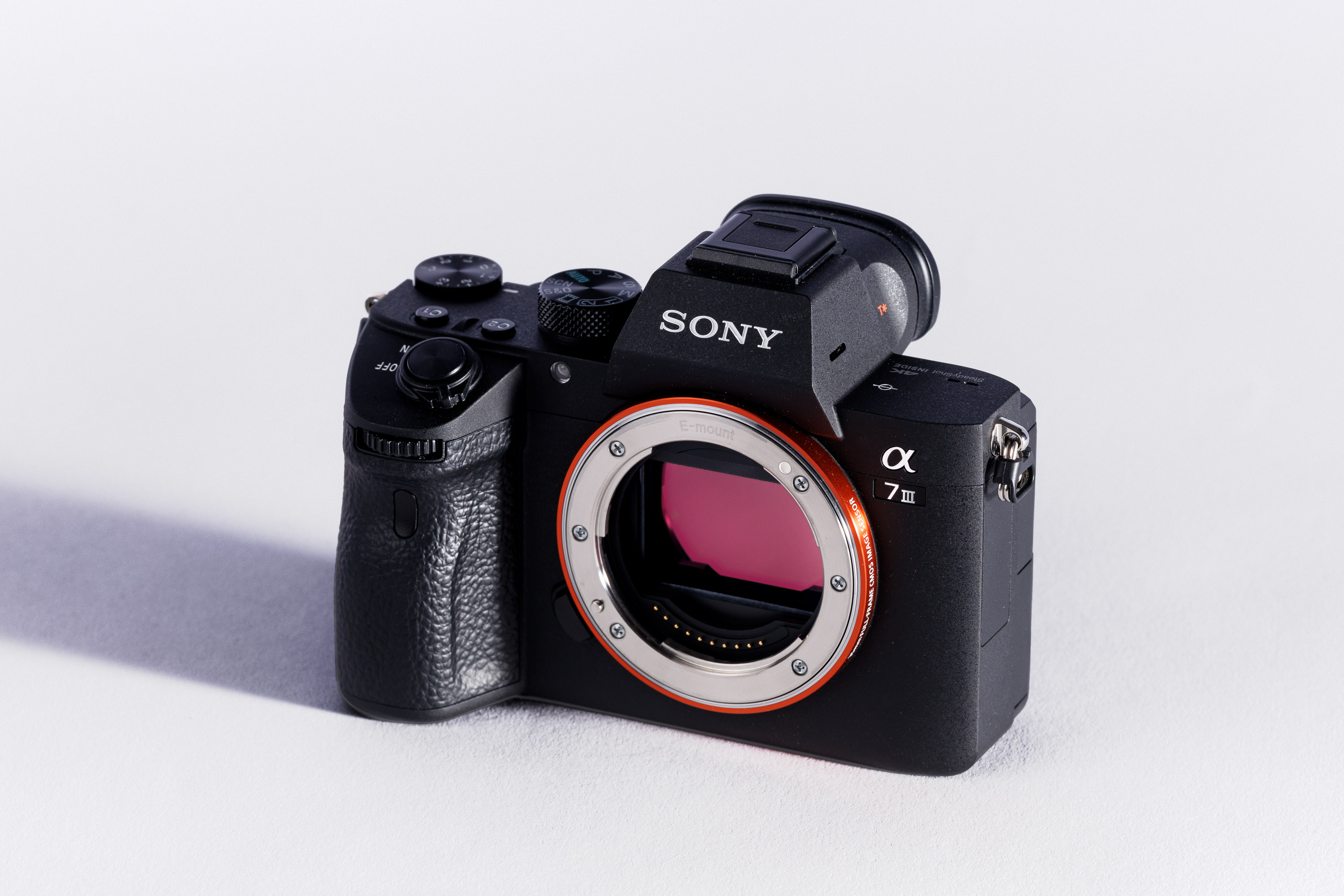 A used Sony A7 III body on a white background, with a shadow to the left. 