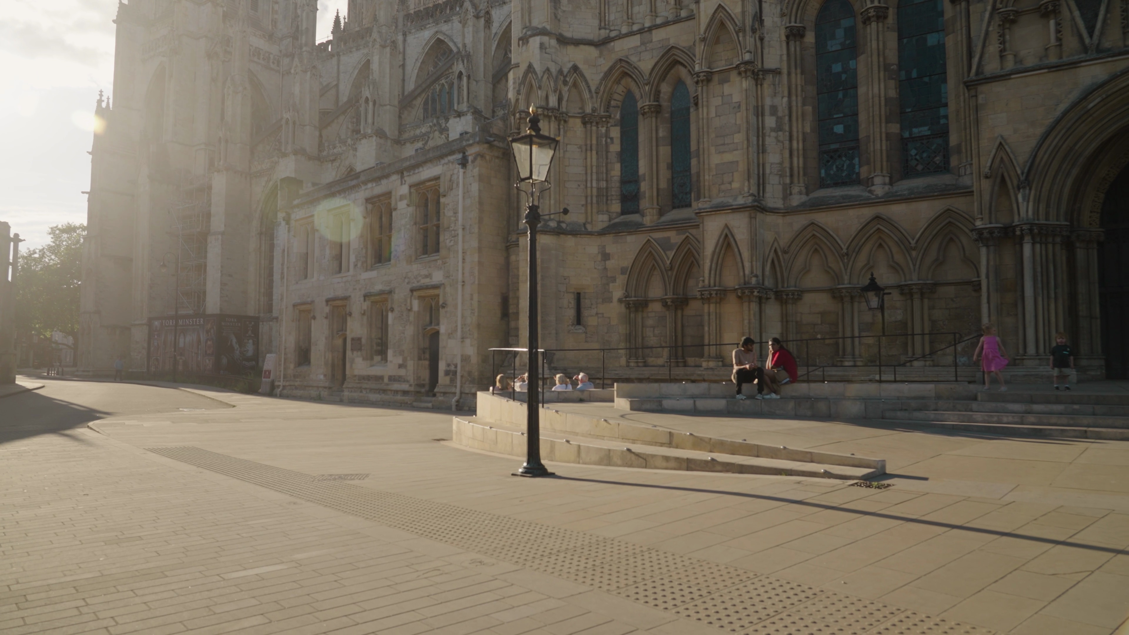 Arrêt sur image d'un lampadaire projetant une longue ombre devant la cathédrale de York.