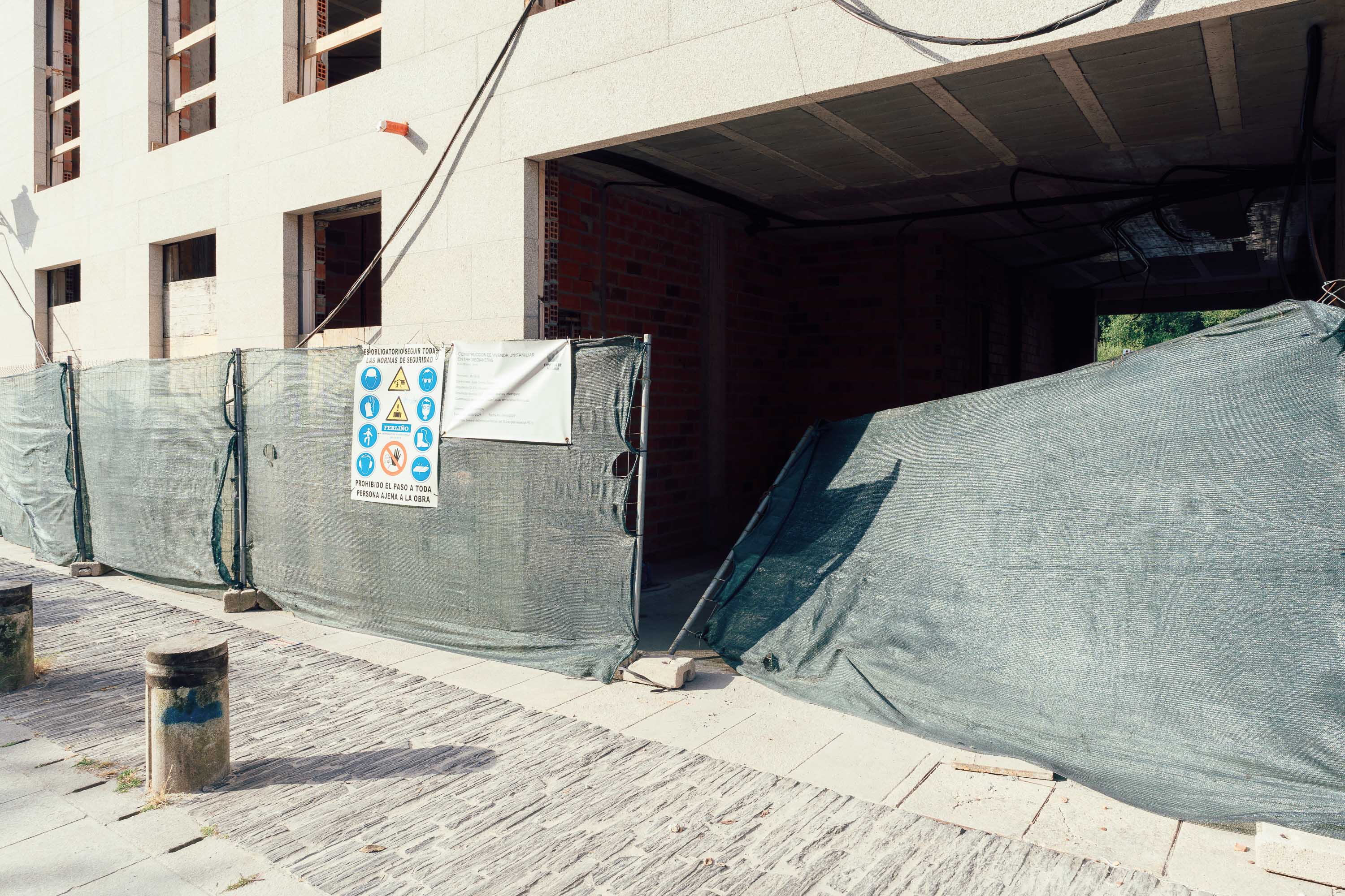 A wide shot of a building mid-construction with a fence blown over. Taken by Connor Redmond on the Sony A7C II. 
