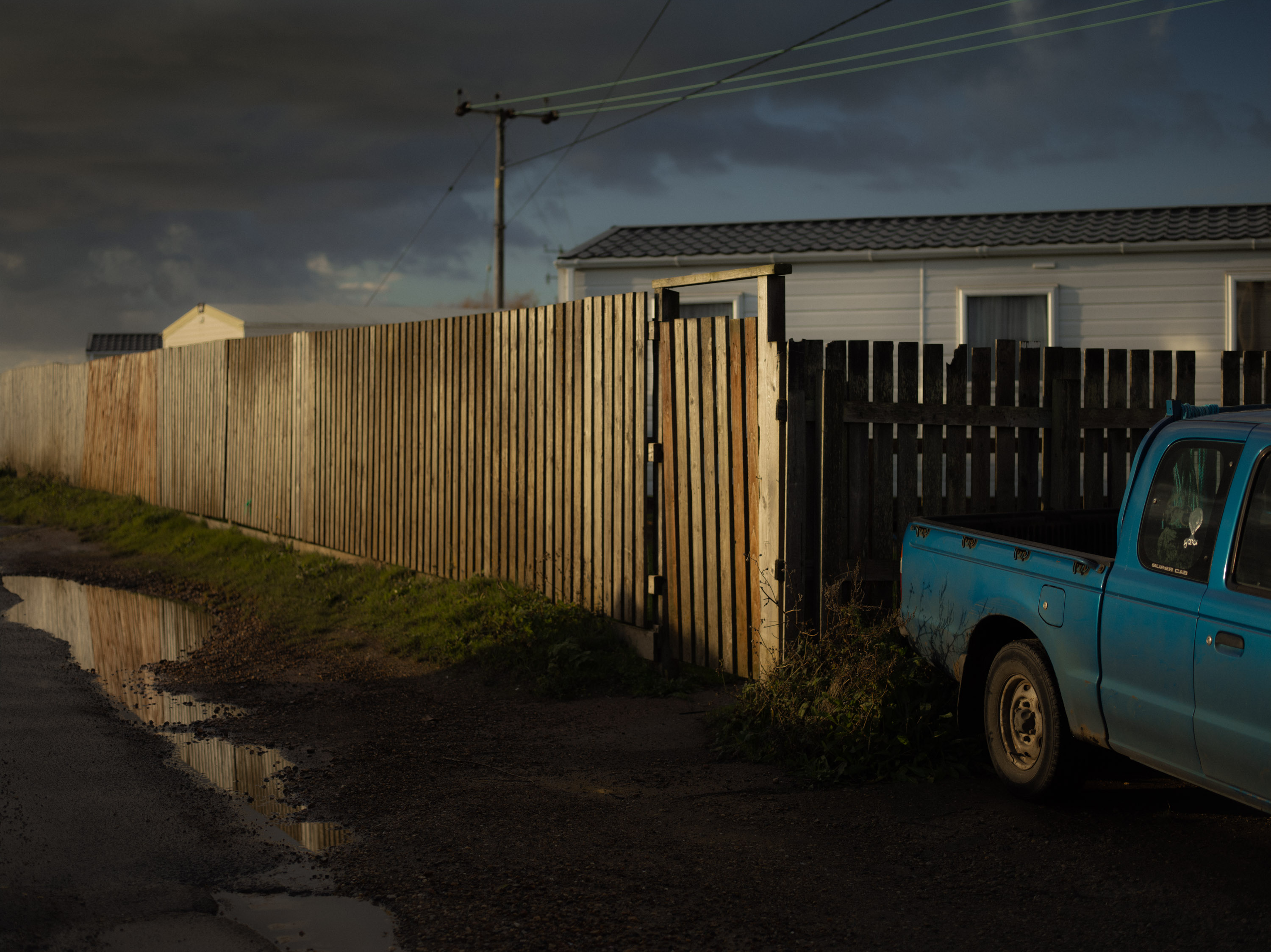 A photo of pickup truck parked by a corner at dusk, shot on Phase One P45 Plus by Ian Howorth