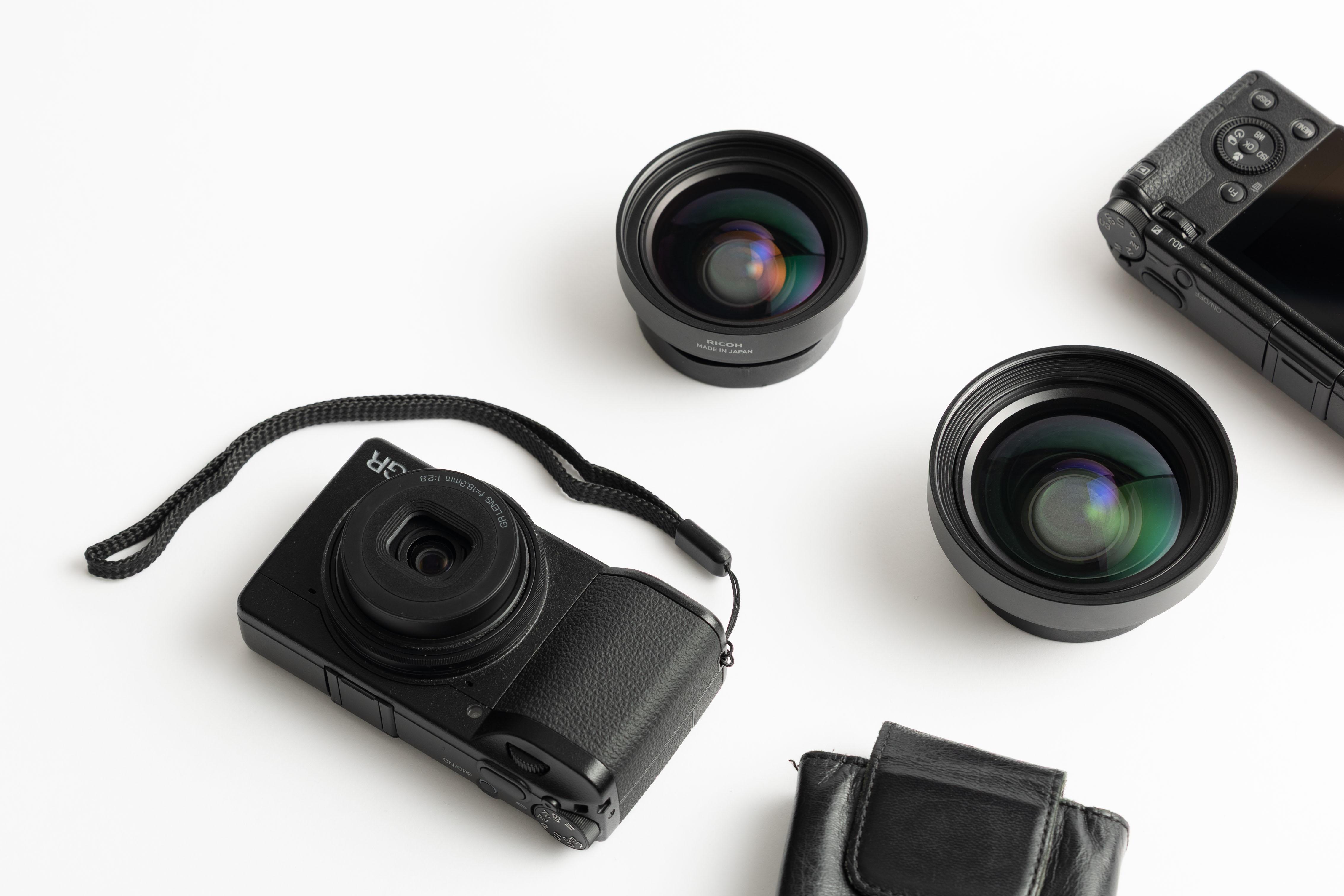 Flatlay von zwei Ricoh GR IVs mit zusätzlichen Konversionsobjektiven und Zubehör