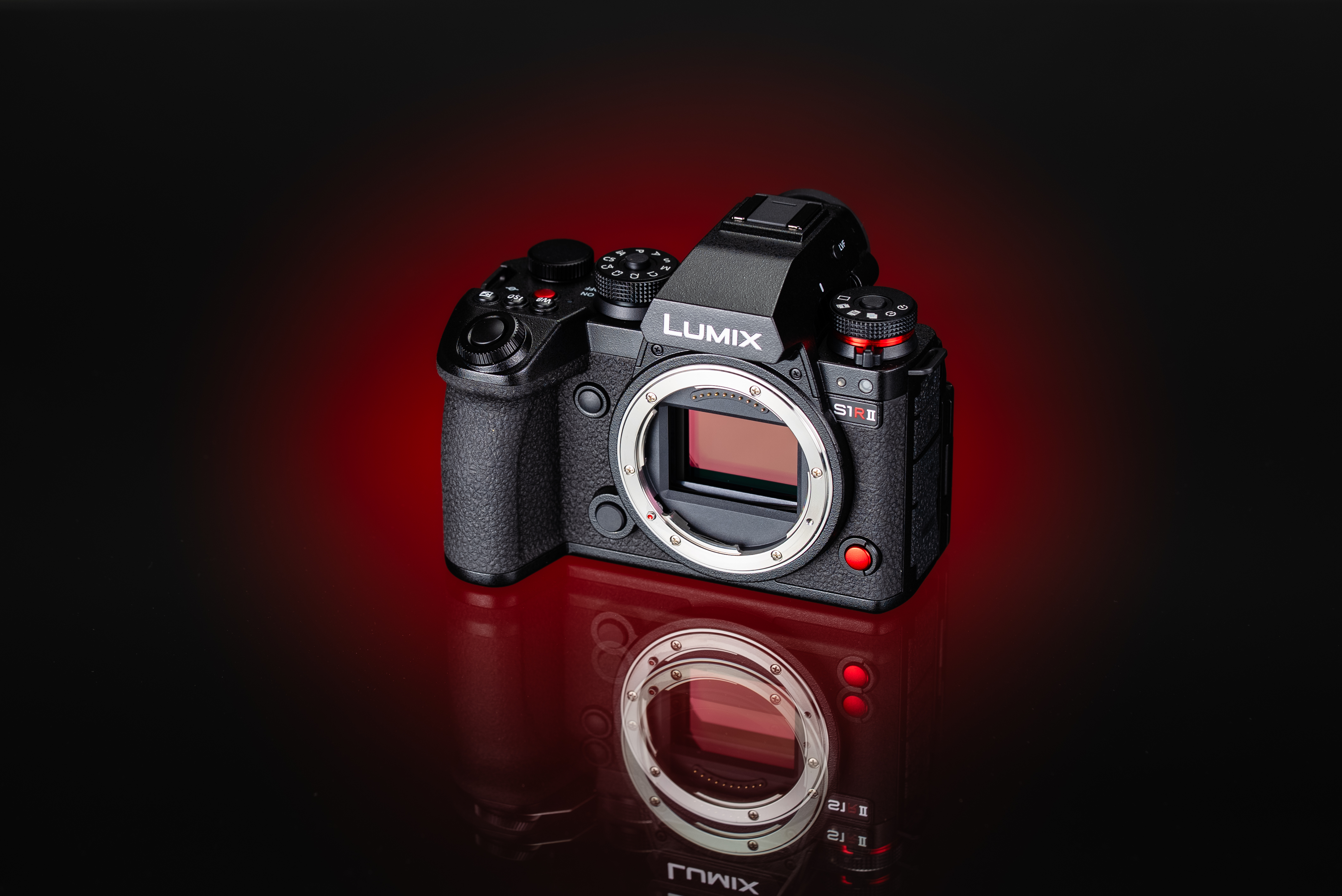 The front of the Panasonic S1R II on a black and red background with a reflection.