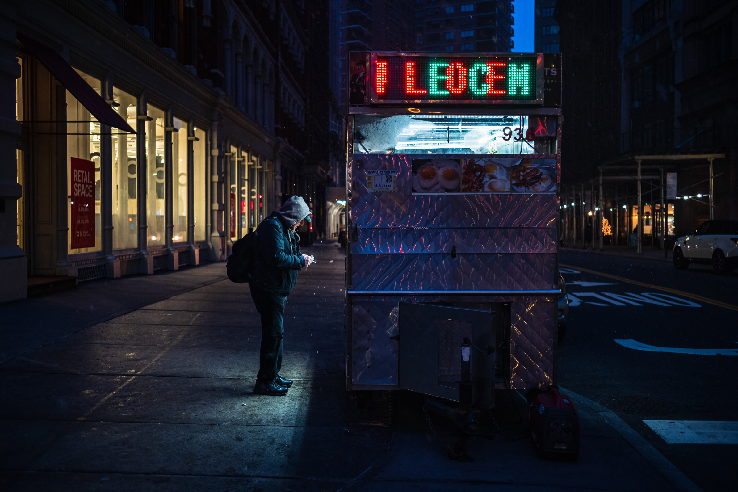 Person ordering from a street food cart in New York City, photo by Manuel Pena.