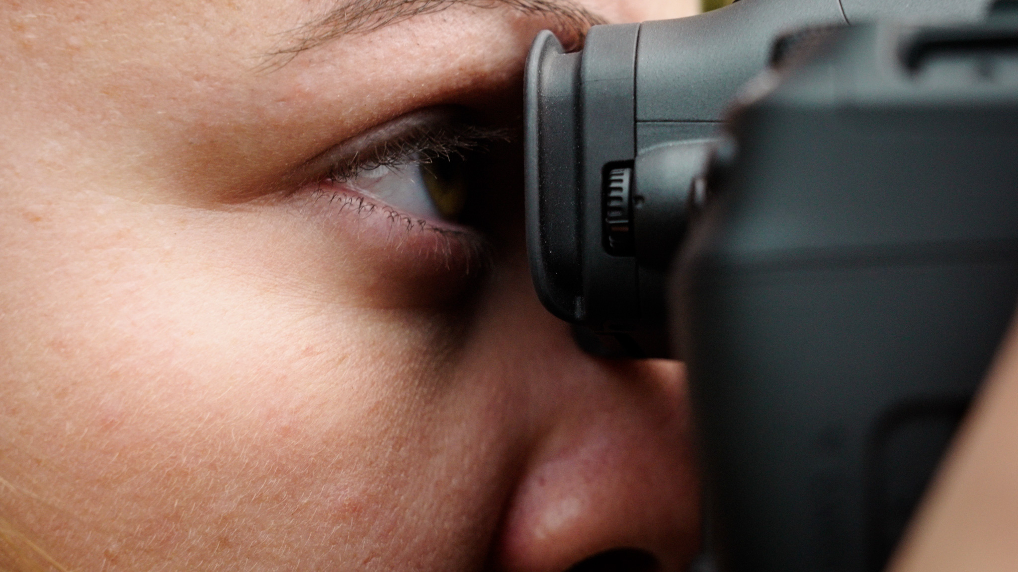 Een close-up van een persoon die door de zoeker van de Canon R5 II kijkt met behulp van de trackingfunctie voor ogen