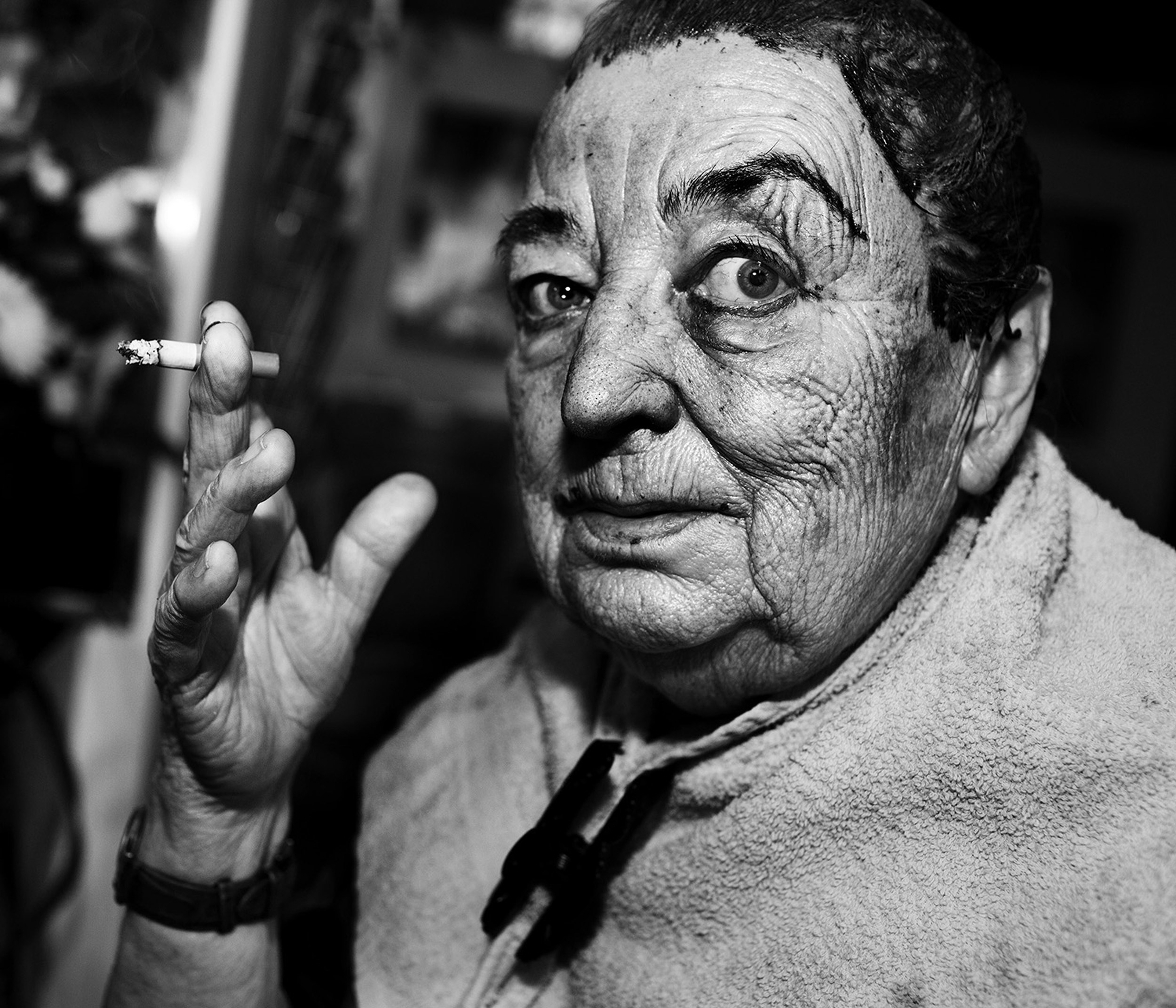 Photo en noir et blanc d'une personne avec une cigarette dans la main droite, regardant directement dans l'appareil photo, photo de Jens Juul
