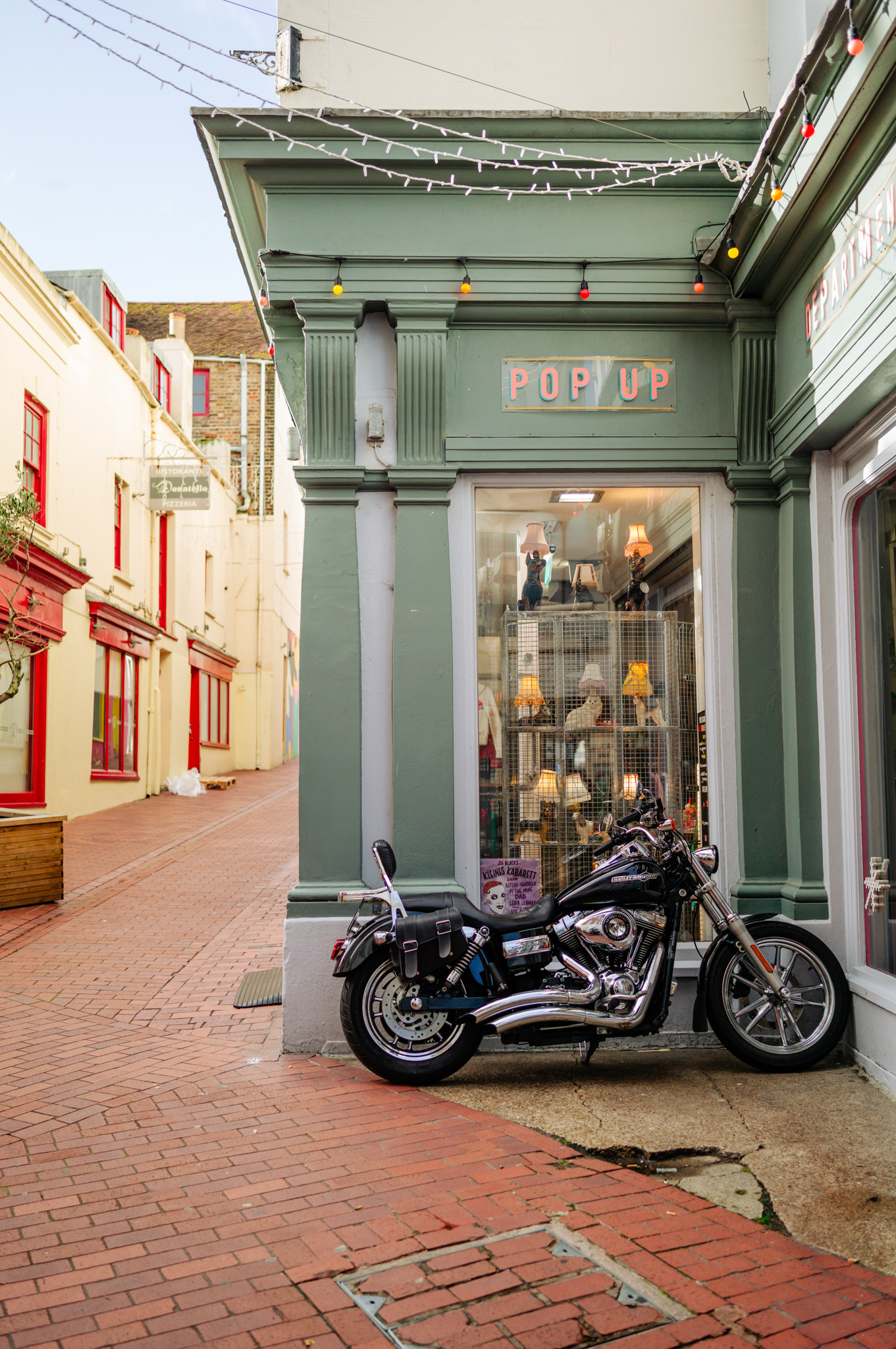 Ein neben einem Geschäft geparktes Motorrad in den South Laines von Brighton, UK 

