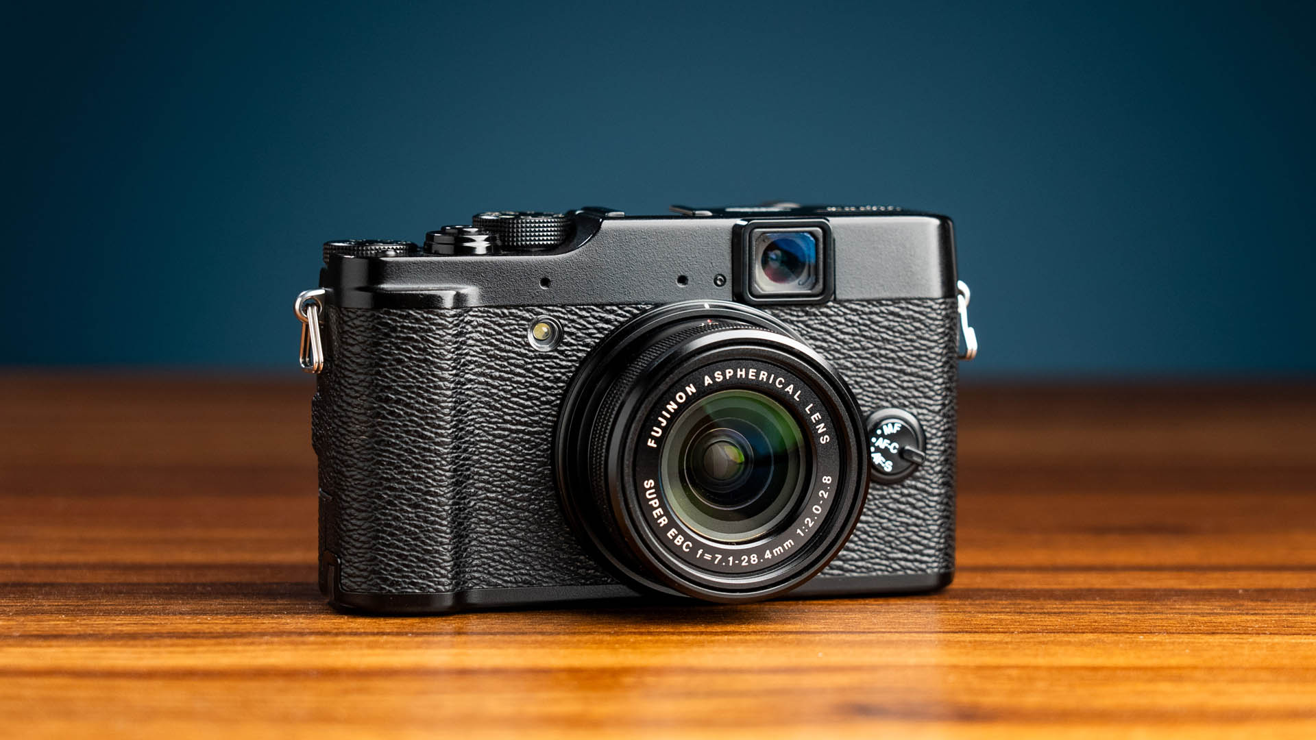 Tweedehands Fujifilm X10 van MPB op een houten tafel