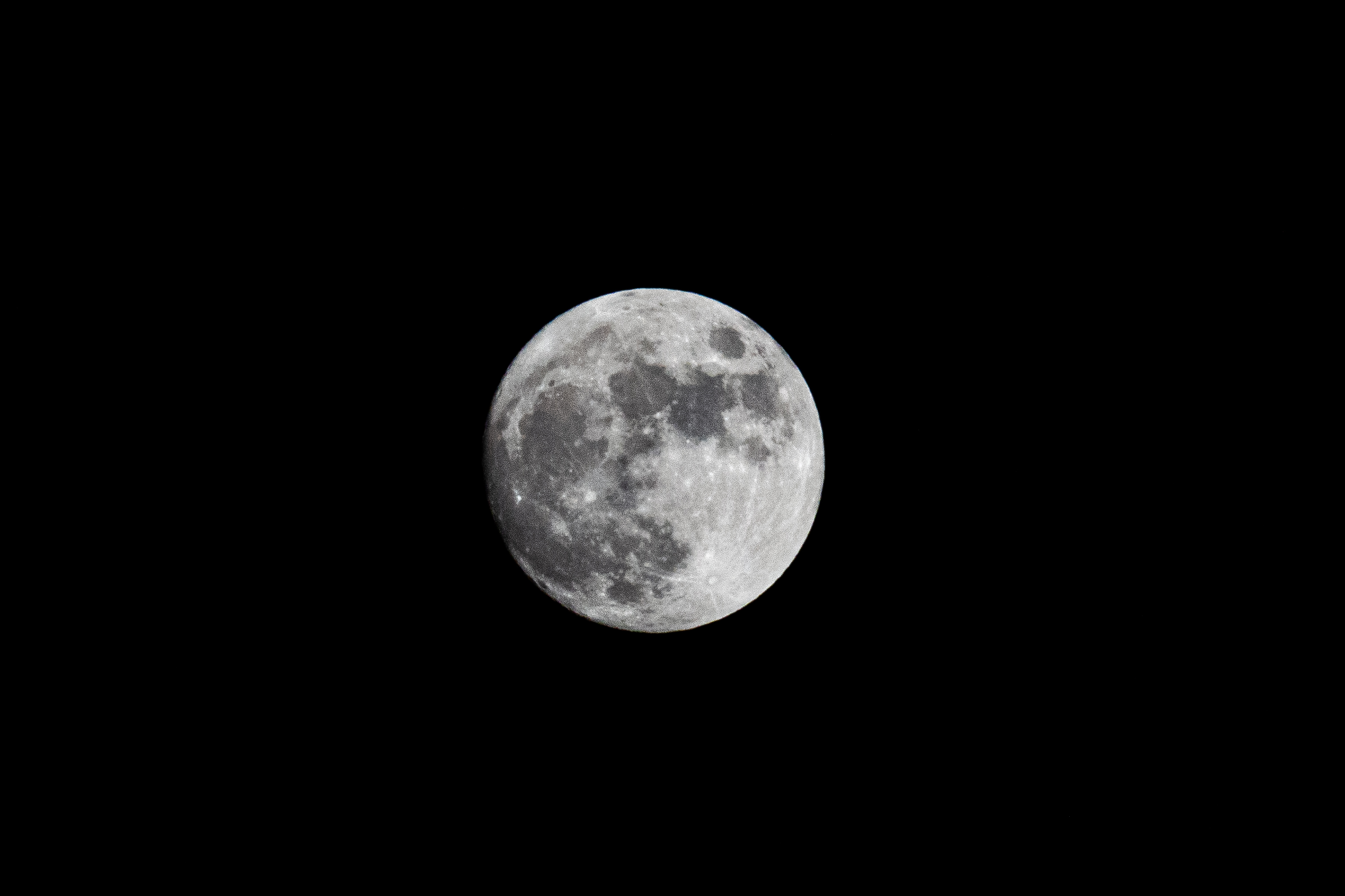 La luna llena fotografiada en el cielo nocturno, con detalles visibles de la superficie lunar.