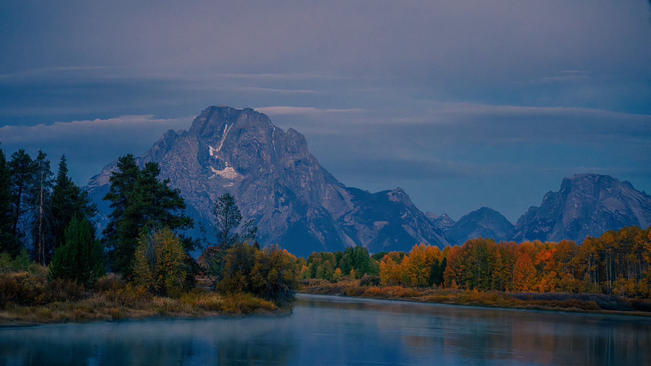 Wyoming mountain at sunrise with water and trees