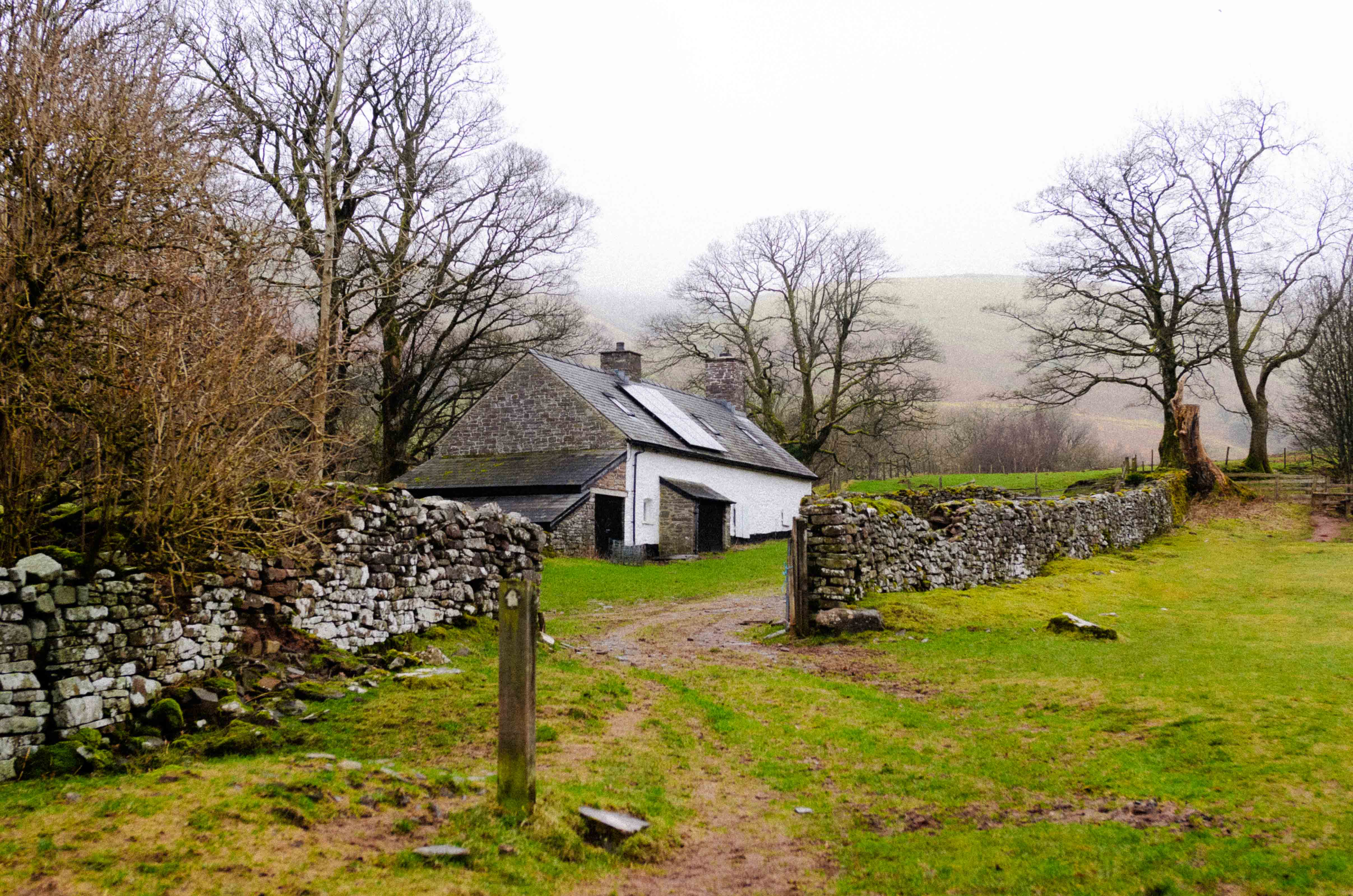 A white and grey slate house in the surrounded by a slate wall in the Brecon Beacons. By Connor Redmond.